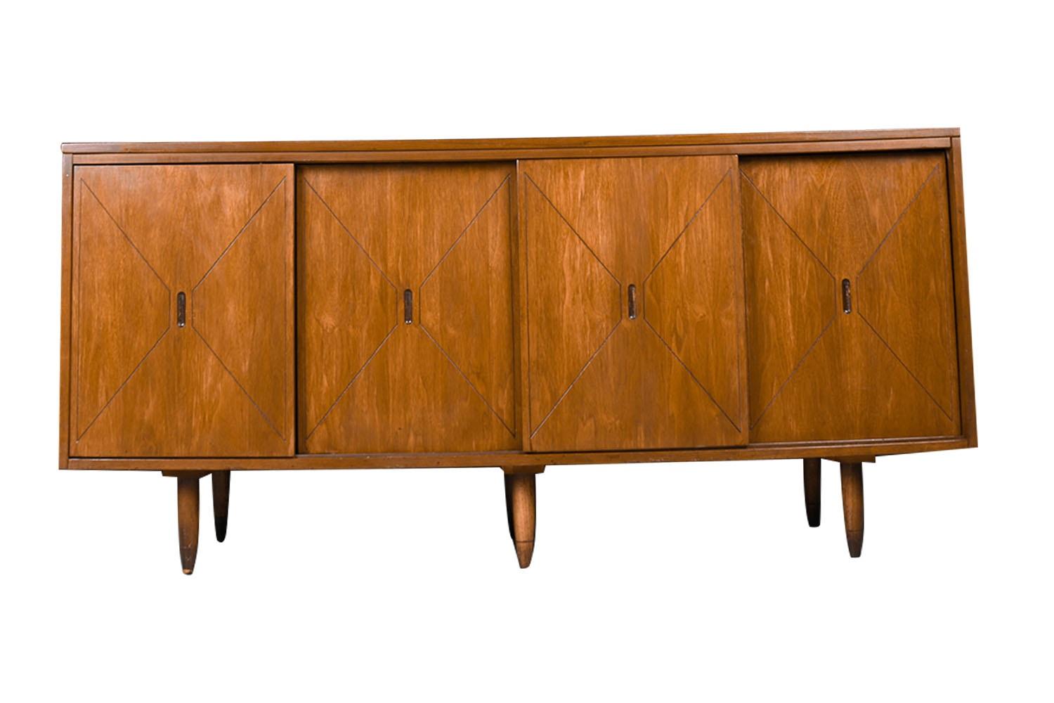 Mid-Century Modern walnut credenza/sideboard in the style of H. Paul Browning Stanley, circa 1960s. This smartly crafted credenza with uniquely Reversible Doors is a perfect collaboration of design and function. Featuring four removable and