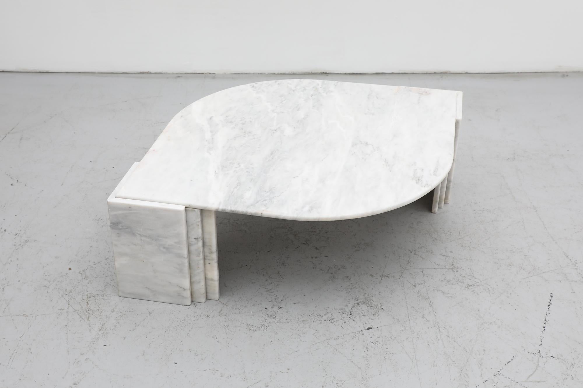 This Italian midcentury solid white and grey marble coffee table has an elegant Post Modern cat's eye design. Attributed to Roche Bobois. The top fits between two double layered angled legs on each corner. In original condition with visible wear,