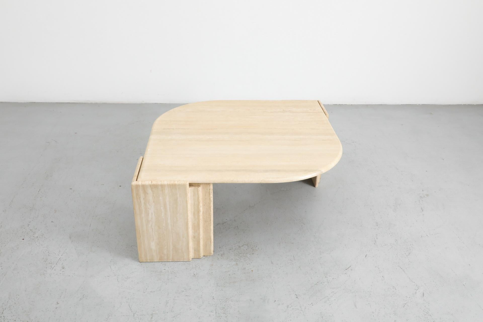 Italian Mid-Century solid wheat toned travertine coffee table. This striking table has an elegant cat's eye design and is attributed to Roche Bobois. In good original condition with visible wear consistent with its age and use. 
