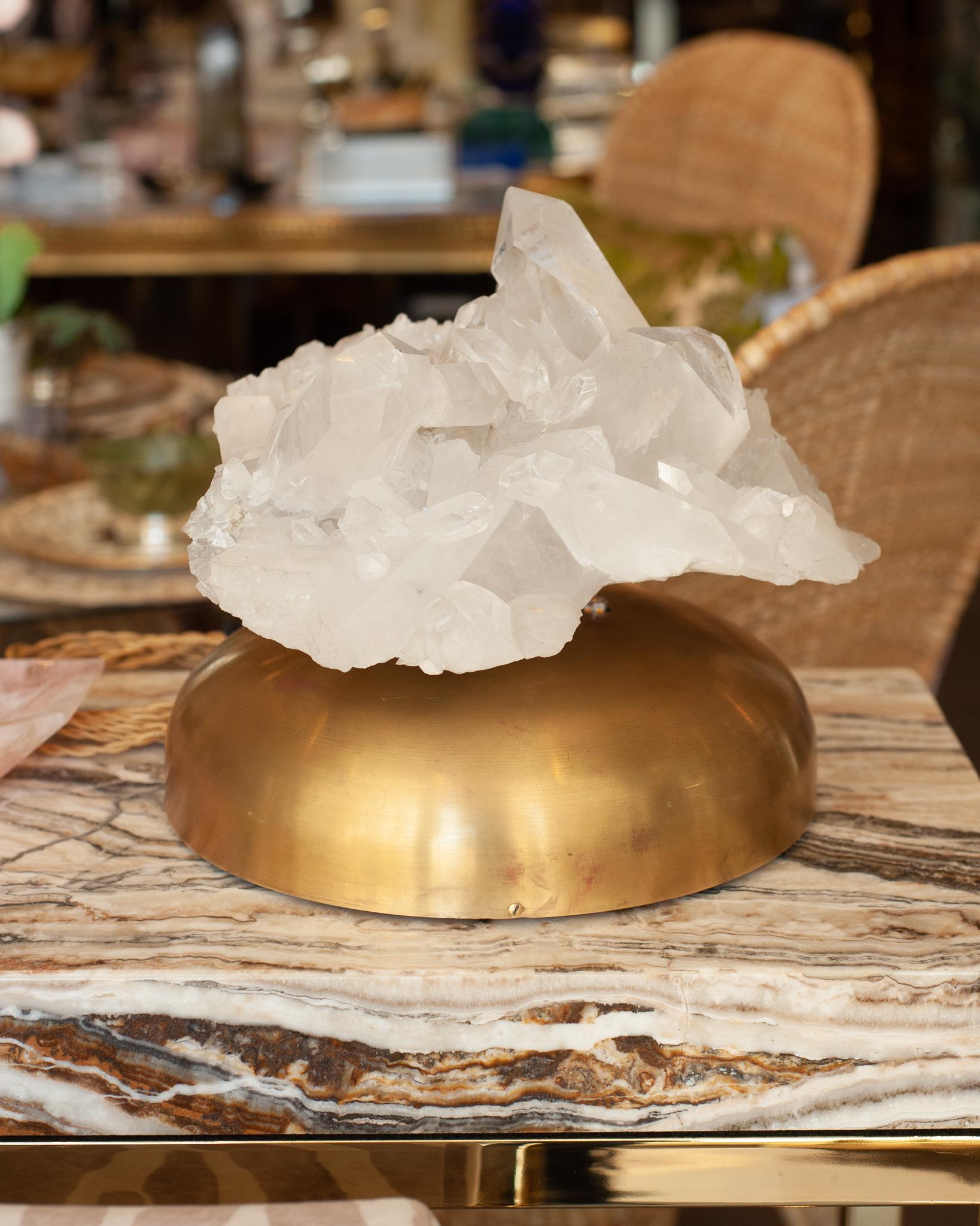 A beautiful and unusual midcentury rock crystal specimen lamp with brass base was sourced in Paris. Illuminated with 3 LED bulbs from beneath the crystal and 1 inside the column attaching the specimen to the base. The base measures 10