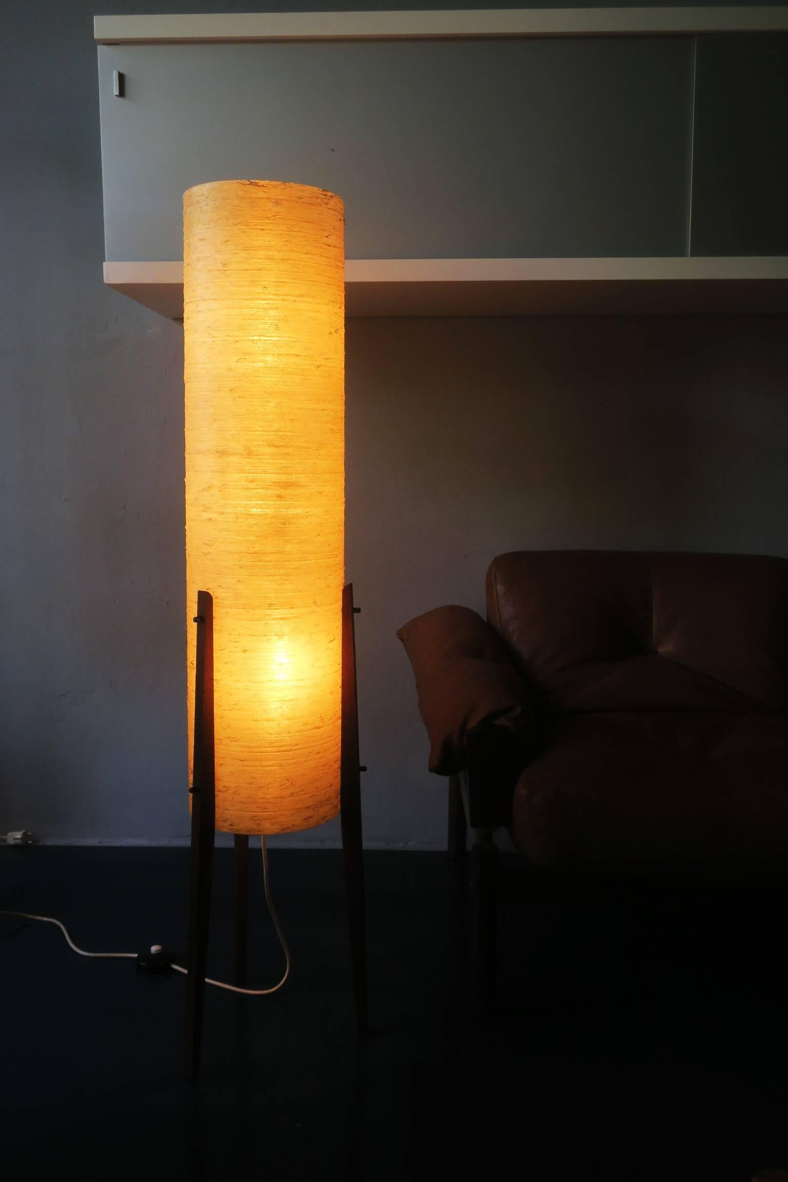 Midcentury rocket floor lamp in fiber glass on teak supports with three light sources.
The three bulb sockets take US or European standard screw-in bulbs.