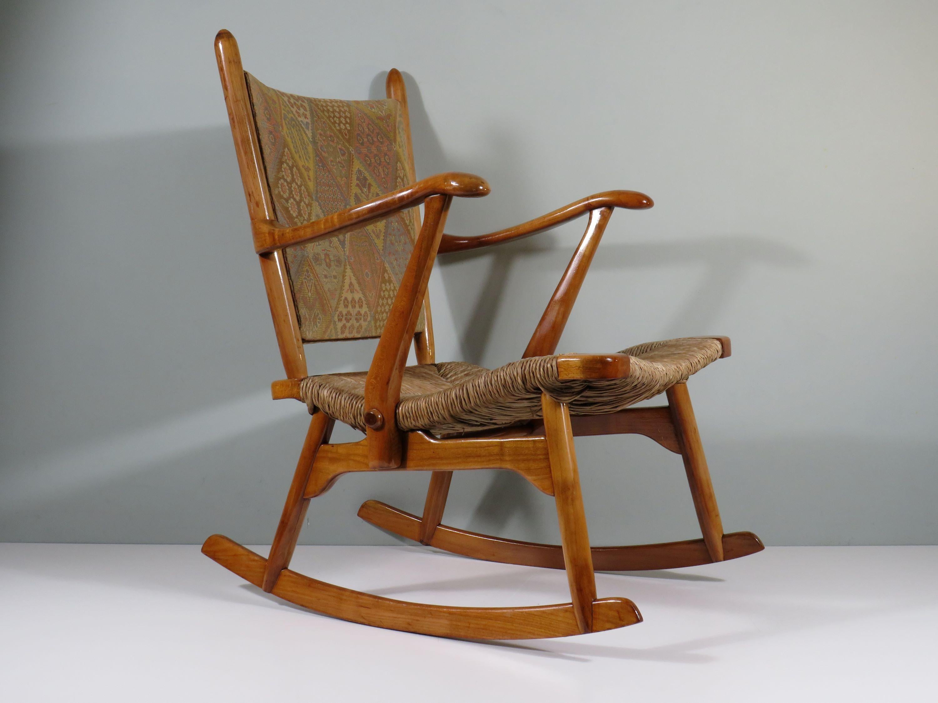 Schaukelstuhl aus lackiertem Holz mit handgeflochtenem Sitz aus Binsen und gepolsterter Rückenlehne mit Originalstoff.
Der organisch gestaltete Stuhl ist in gutem und stabilem Zustand.
Die Sitzhöhe beträgt 40 cm an der Vorderseite des Sitzes und 34