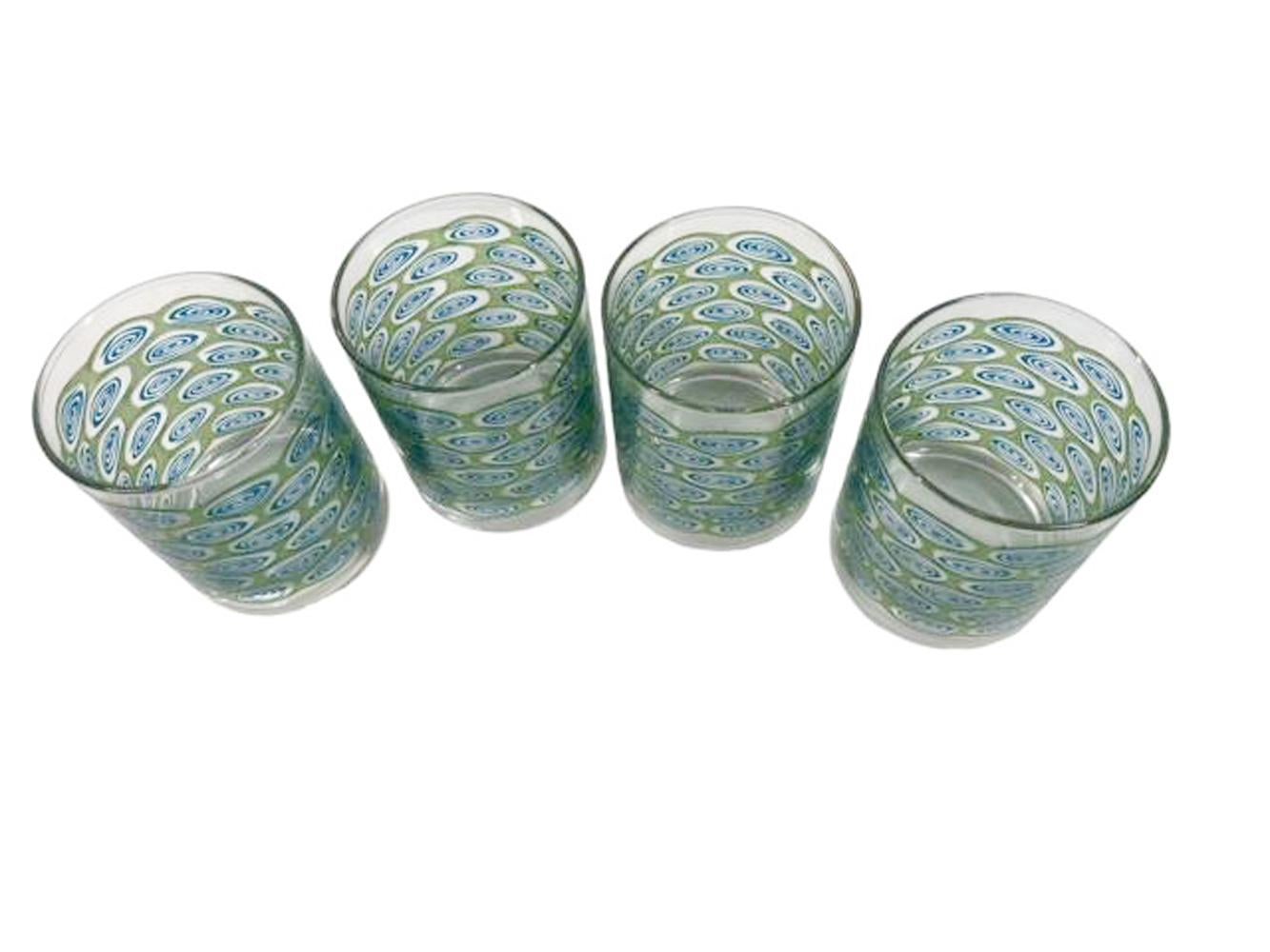 Quatre verres à whisky modernes de Libbey Glass en verre translucide vert sur verre transparent avec des réserves ovales remplies de spirales bleues.