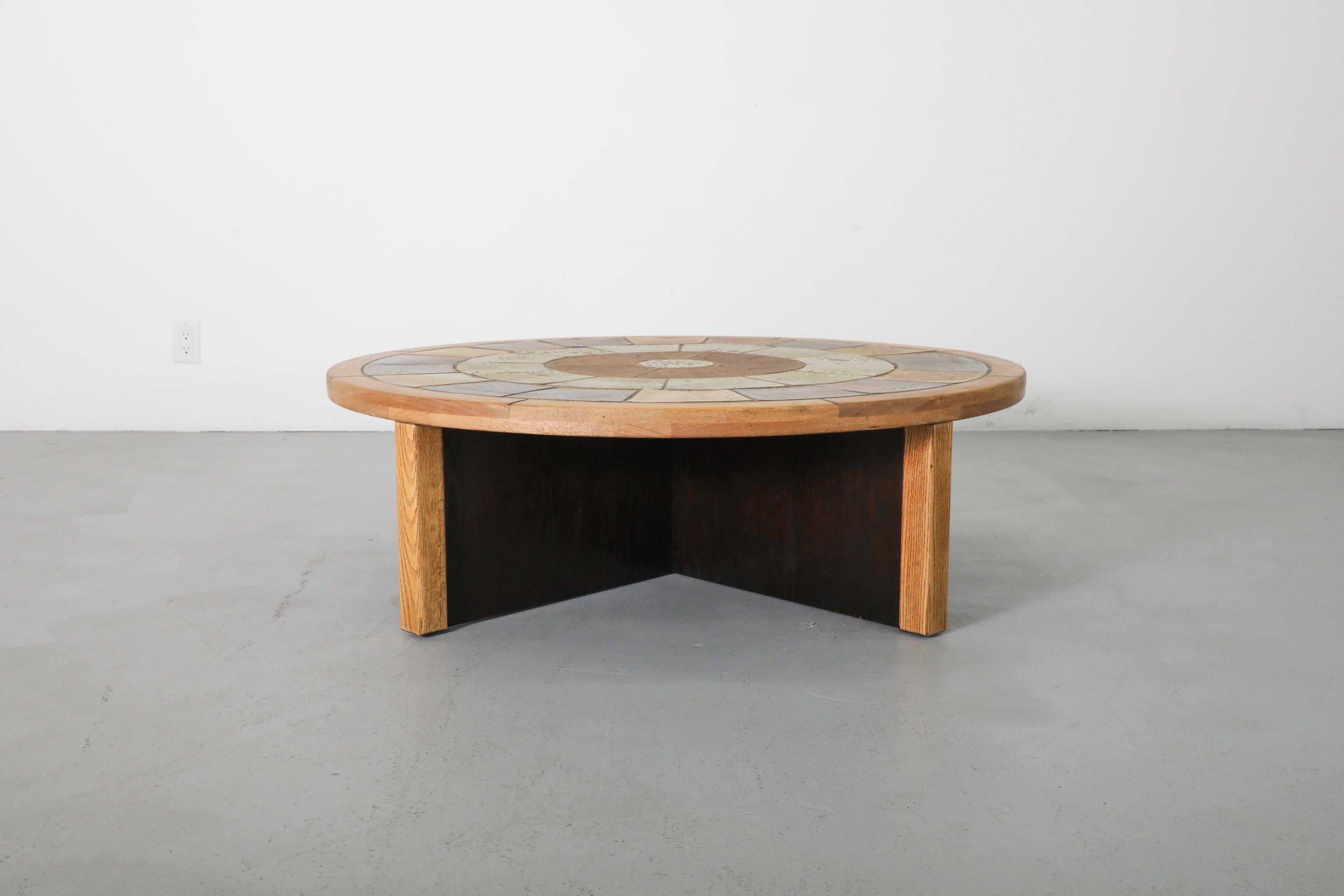 This Mid-Century, 1960s coffee or side table in the style of Roger Capron has a two-toned oak frame and inset ceramic tiles. Designed by Denmark's Tue Poulsen, who is best known as a sculptor and ceramicist. Poulsen designed a set of tables in the