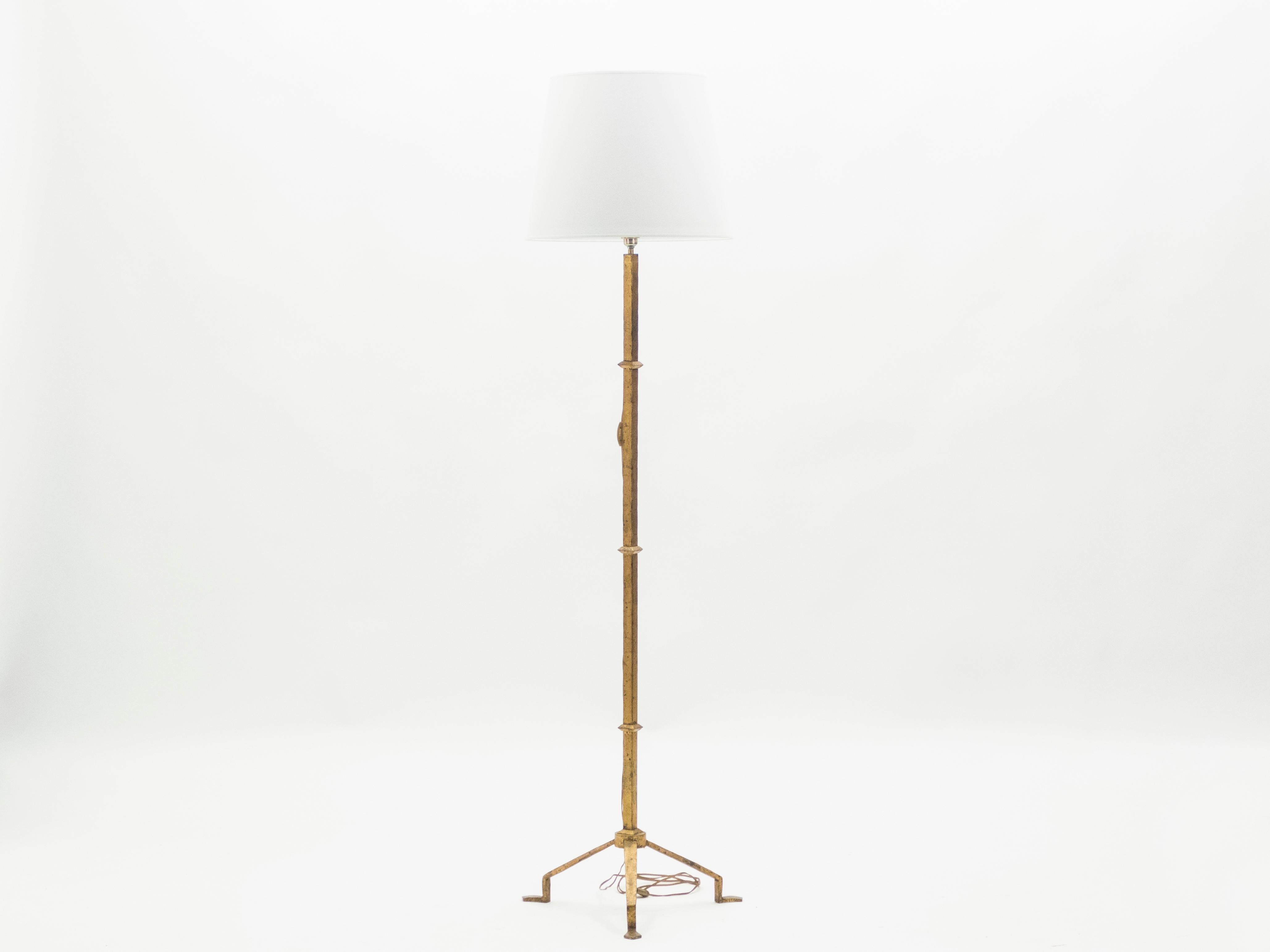 A strategically sparse design with high quality materials gives this rare floor lamp all its appeal. Wrought iron has been gilded with gold leaf for a gentle warm golden patina throughout the entire structure. Designed by Parisian decorators and