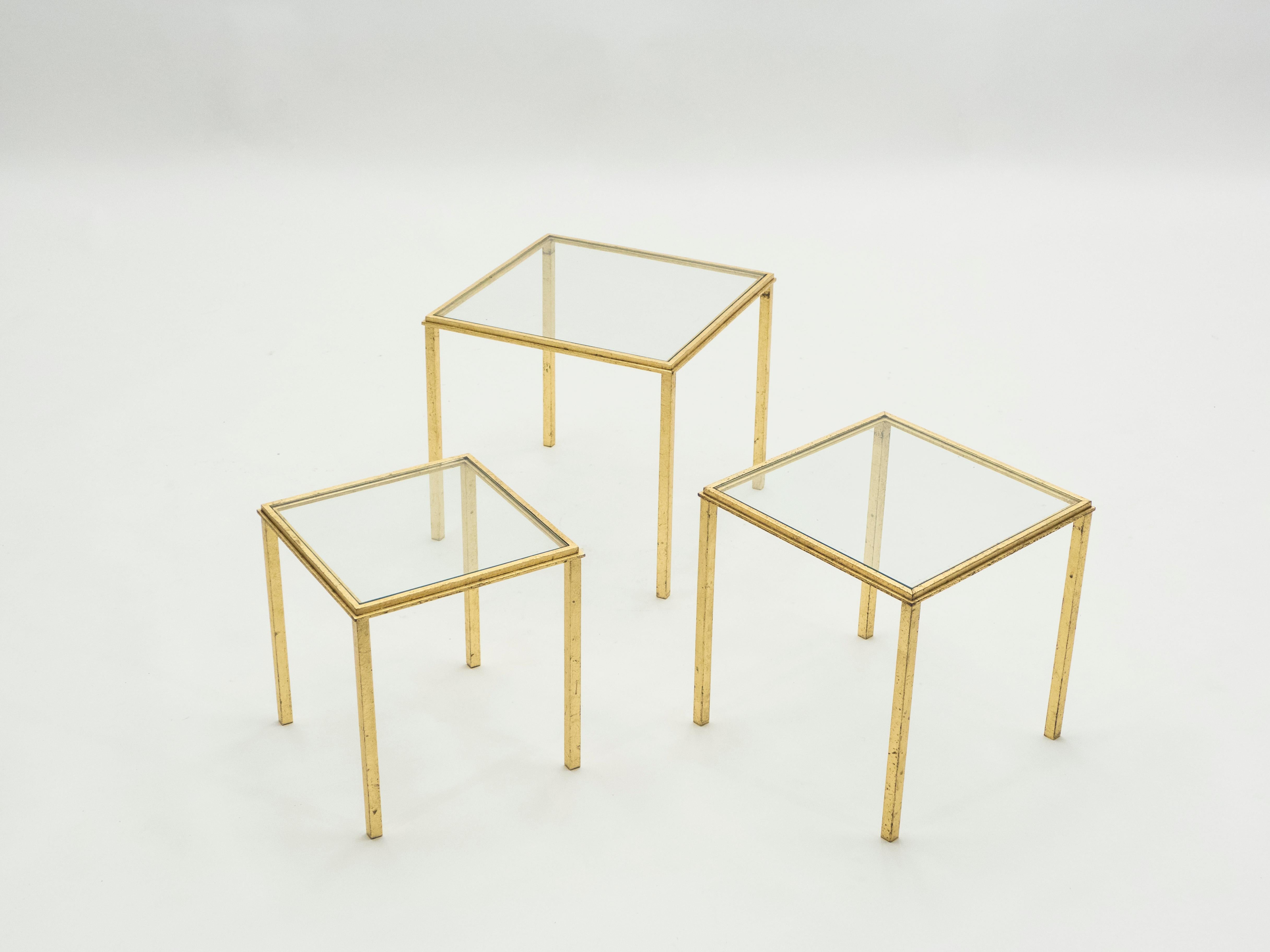 Simple lines point to this nesting tables midcentury roots. Designed by Roger and Robert Thibier, it features silky wrought iron legs that has been gilded with gold leaf for a gentle warm golden patina throughout the entire structure. Its symmetry,