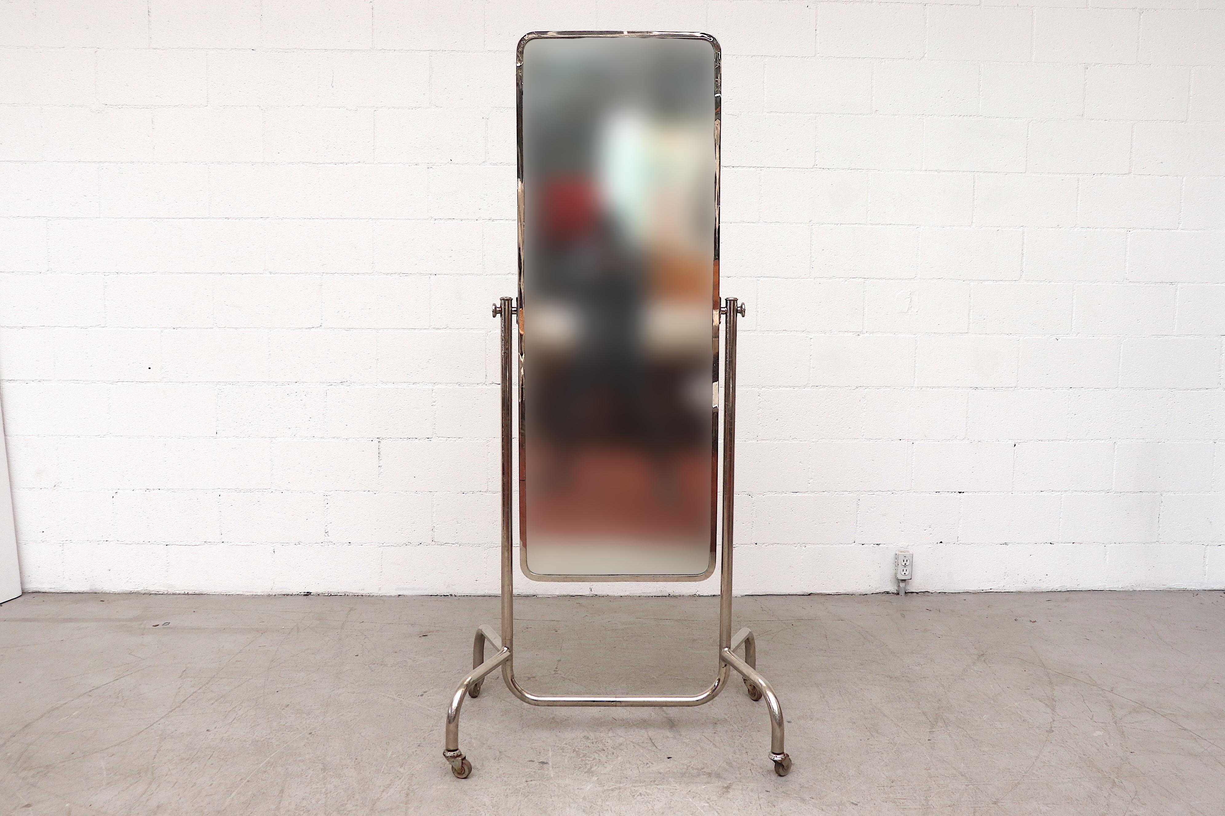Rare mid-century full-length rolling mirror with chrome tubular frame. In very original condition with original tag and visible mirror wear and oxidation. Frame has noticeable patina consistent with age. Similar mirrors also available.