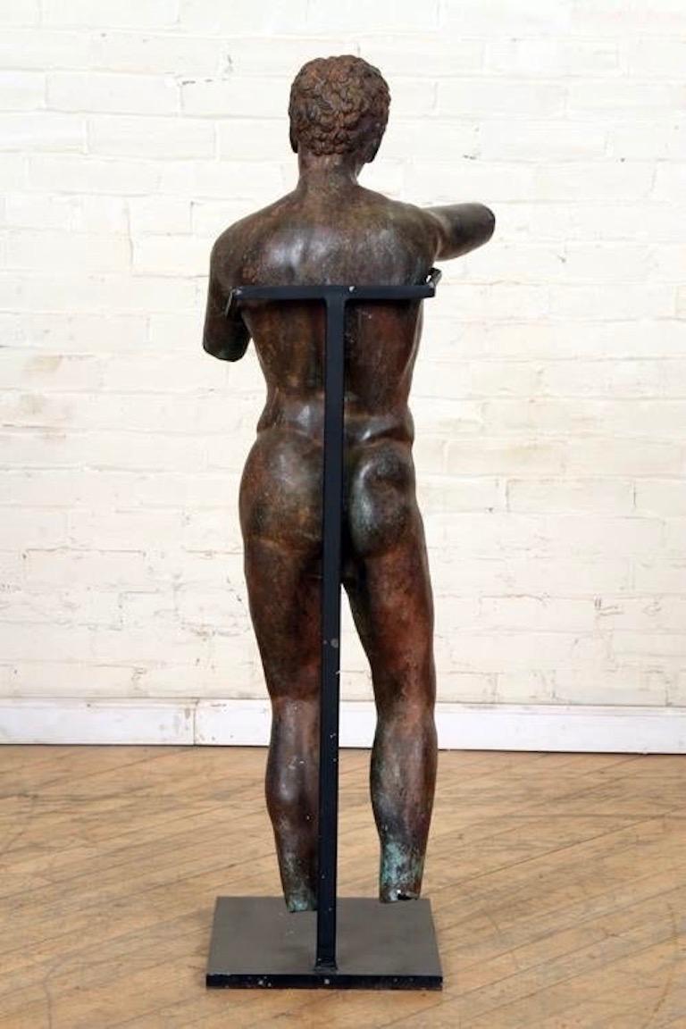 Mid-20th century patinated bronze sculpture of a Classical Roman male after the antique. Now held by modern iron stand. Classically posed and masterful patina.