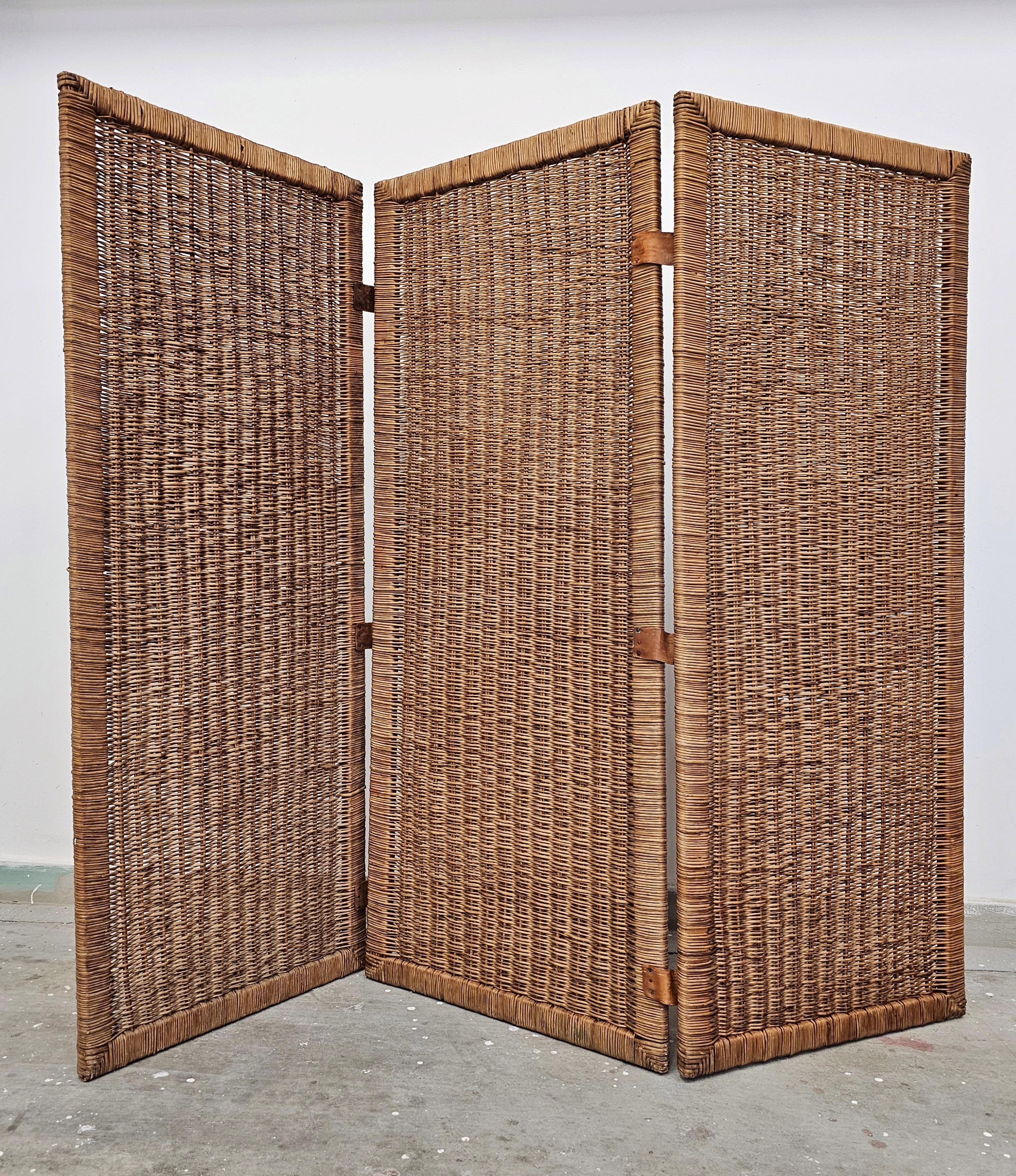 In this listing you will find a beautiful Mid Century Modern  three panel room divider screen which is done in rattan. Three panels it consist of are connected with the leather connectors. Made in Italy in 1960s.

Good vintage condition with some