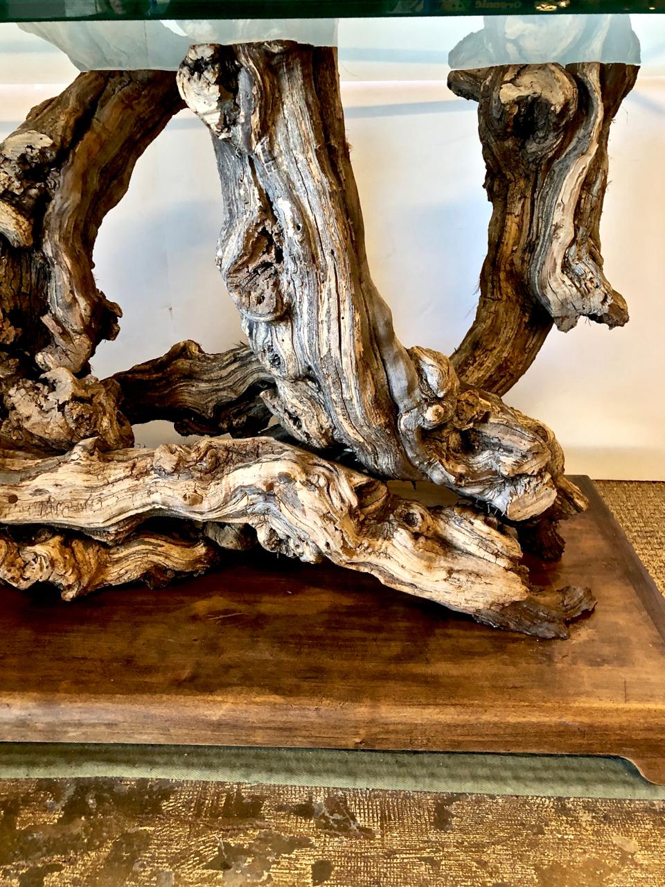 This is a superb example of a midcentury table that was created by intertwining large sculptural roots. The table spent many years out of doors acquiring a deep natural patina. The base has been newly strengthened and placed on a custom plinth. The