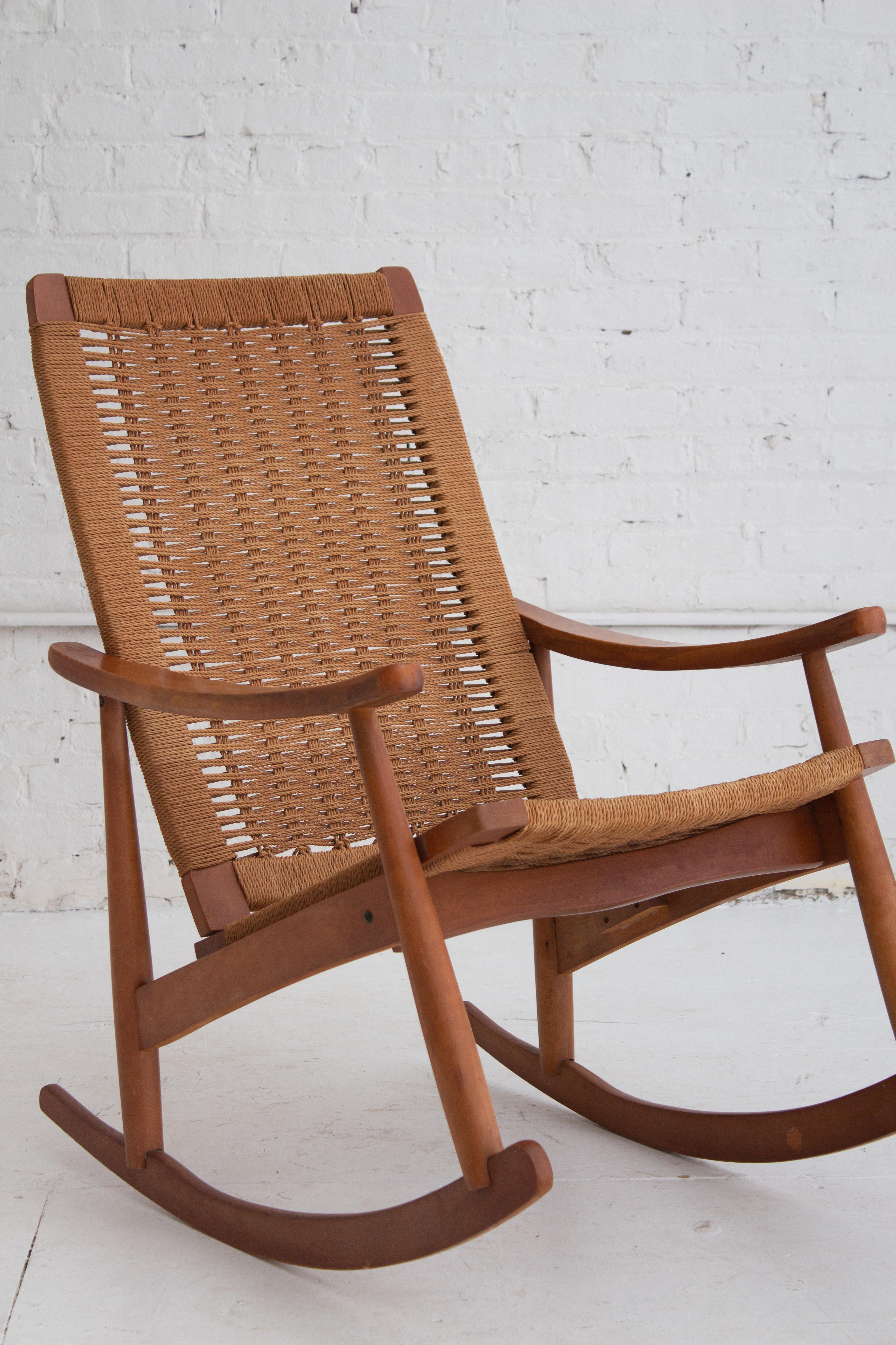 A midcentury woven rope rocker in the style of Hans Wegner. Twisted rope cord is woven over a wood frame. Marked “Made in Yugoslavia.”