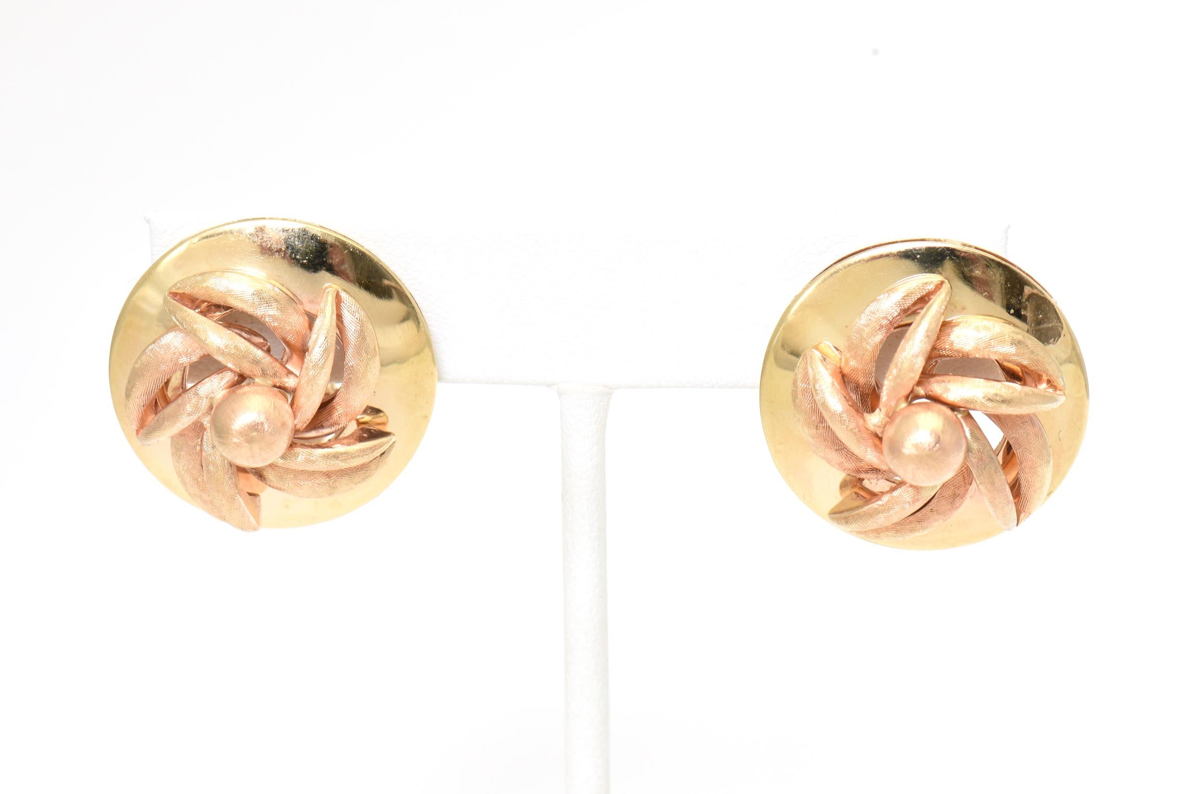 Mid century round 14K yellow gold disk earrings with an applied 14K rose gold Florentine flower. Post backs with an attached hoop. Marked 14K on the clips.
