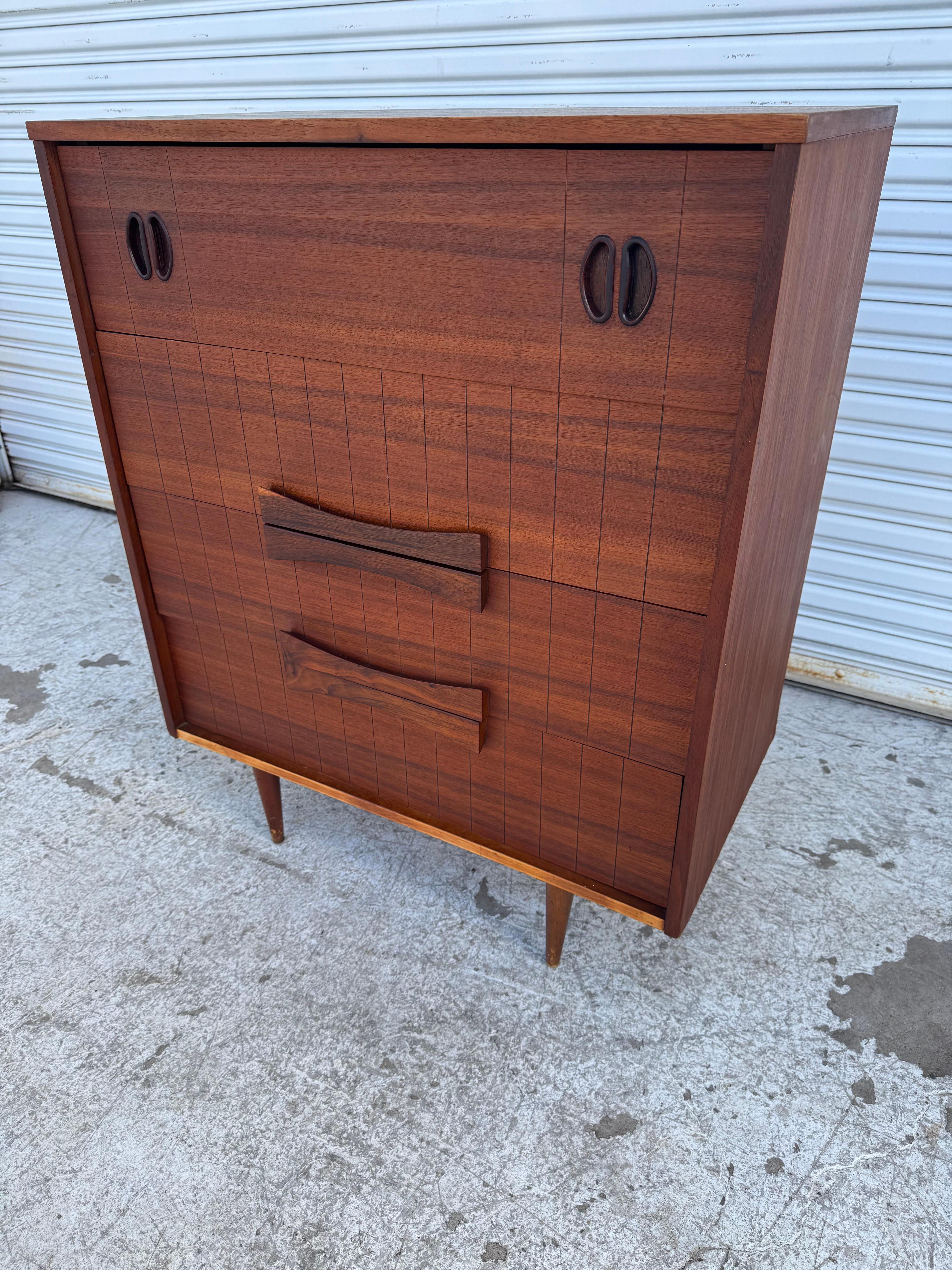 Esta cómoda de 4 cajones está fabricada en palisandro de grano fino.
Los tiradores del cajón superior están embutidos en palisandro.
El arcón se asienta sobre patas de par de puntos.