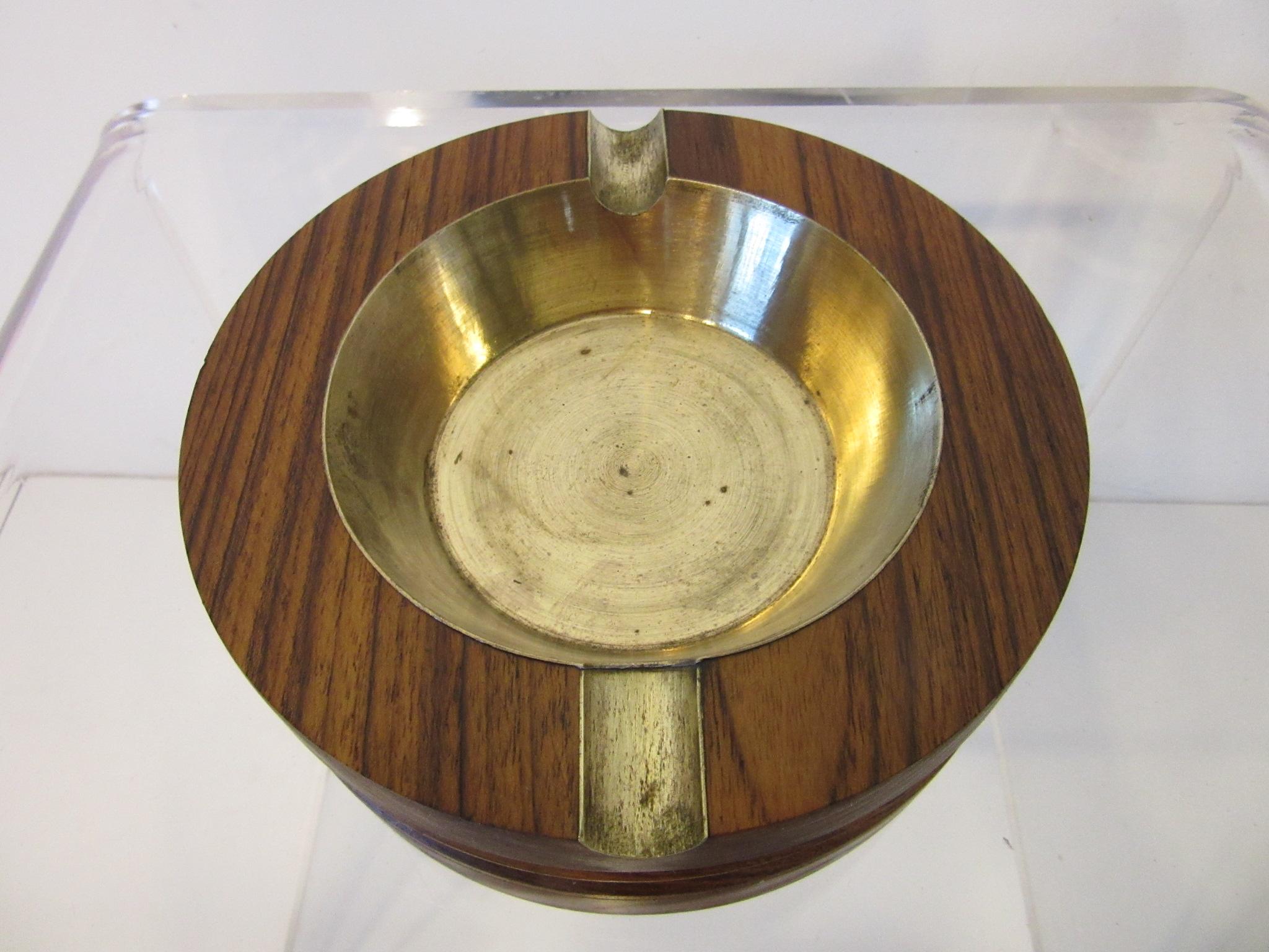 A rich large dark midcentury rosewood ashtray with brass bowl having two slots, this heavy solid piece has the designers branded mark to the bottom 