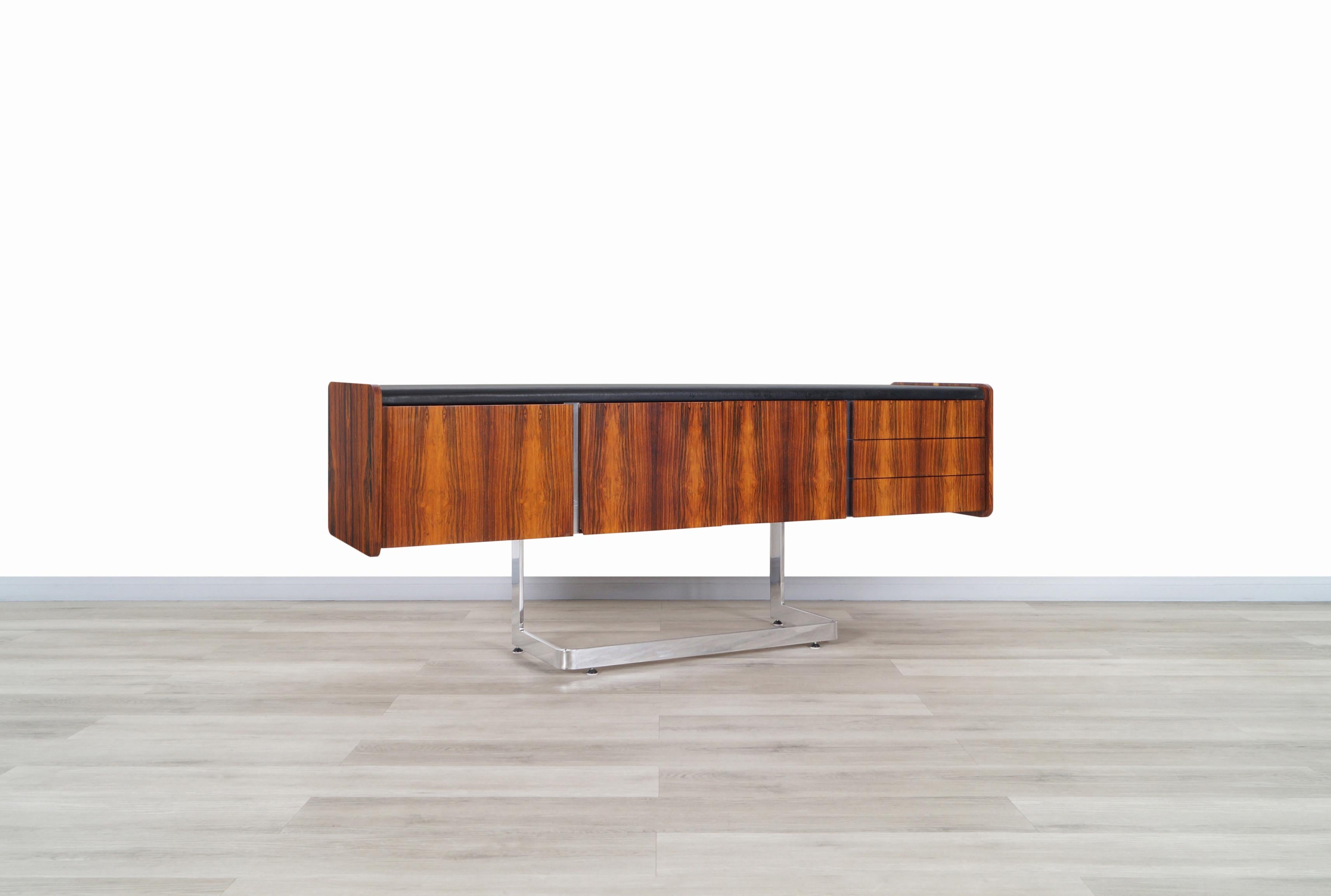 Amazing midcentury rosewood and chrome credenza designed and manufactured by Ste. Marie and Laurent in Canada, circa 1960s. This credenza stands out for its fine rosewood grains that surround the case; on the surface, we have an elegant black