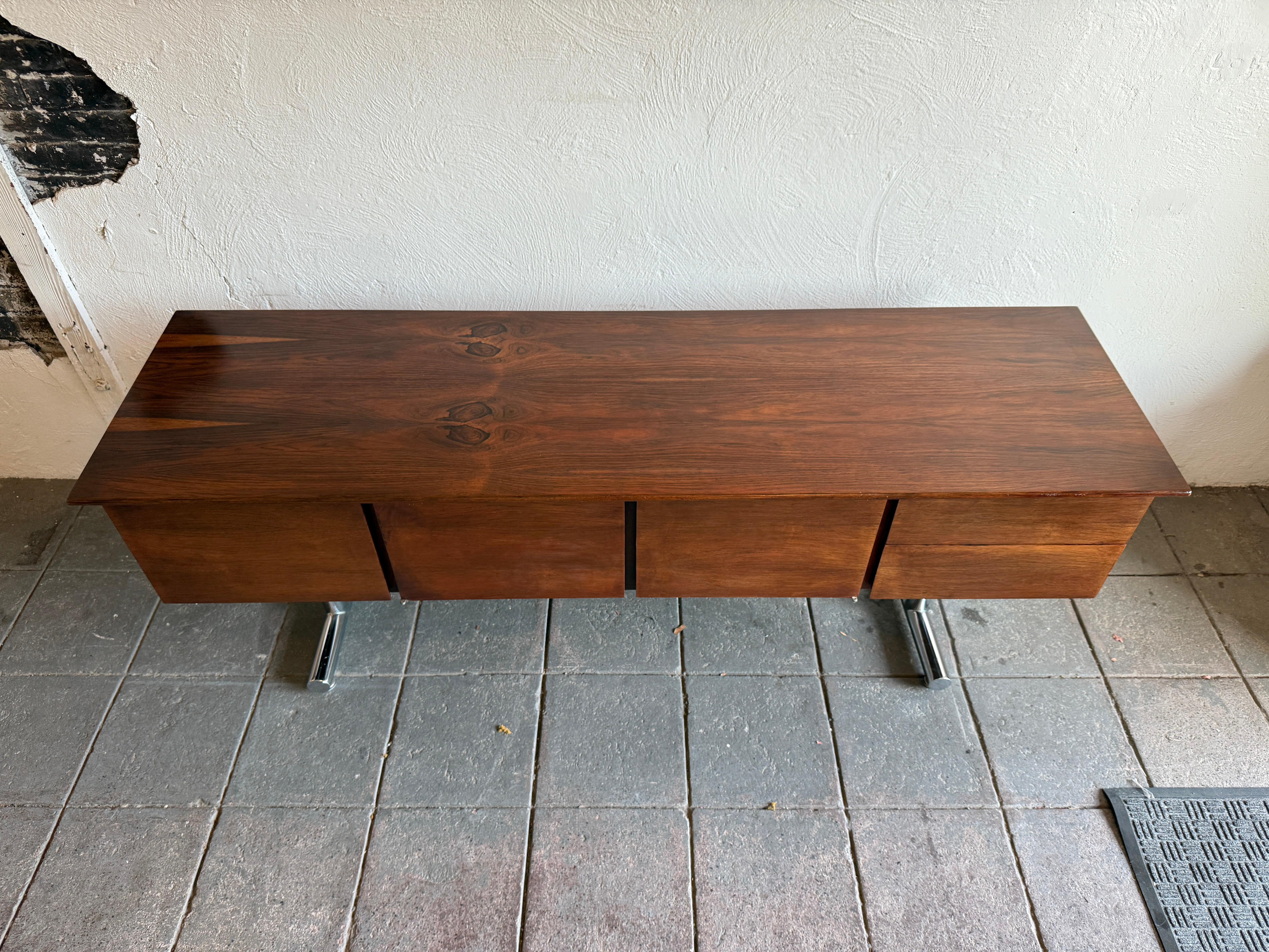 Bellissima credenza fluttuante in palissandro di metà secolo a 2 ante e 3 cassetti su una base in tubo cromato. Bellissime venature sulla parte superiore con una costruzione di altissimo livello. Il cassetto sinistro contiene le cartelle e le due