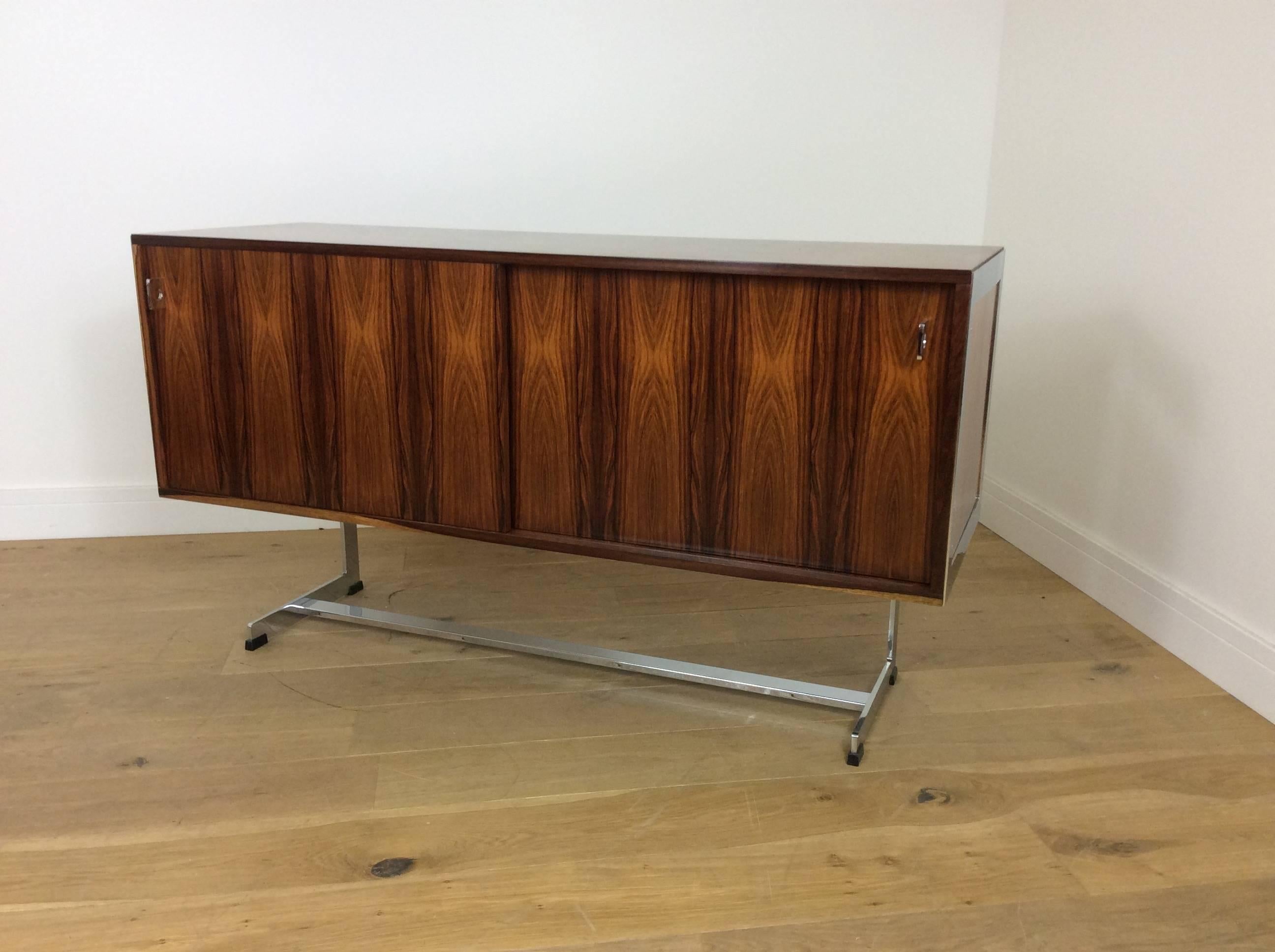 Midcentury rosewood and chrome sideboard by Merrow Associates.
Beautiful rosewood with high quality flat chrome, makes this a very desirable and extremely stylish sideboard or credenza.
Designed by Richard Young for Merrow Associates.
British,