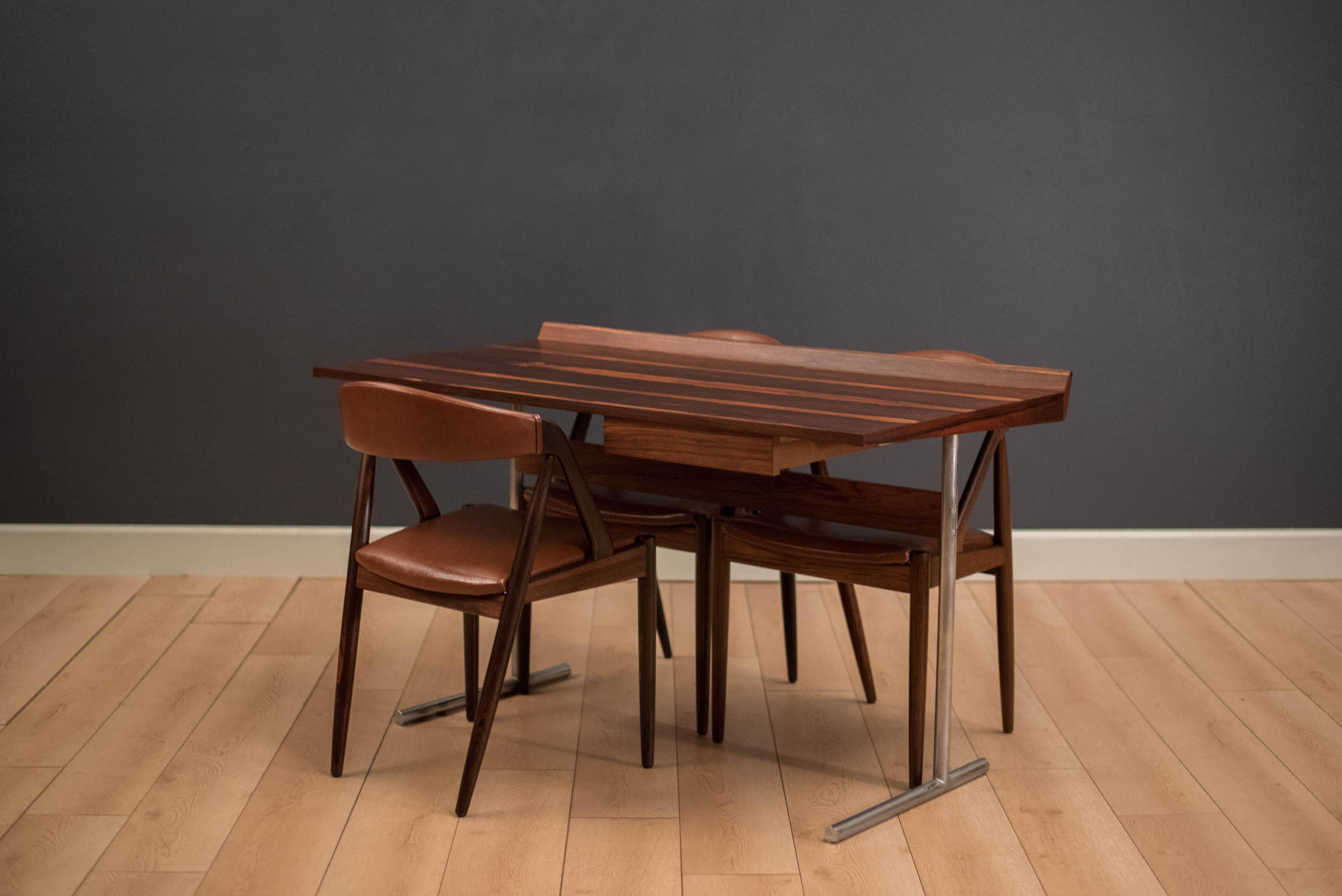 Vintage rosewood writing desk made in Western Germany. This piece features a raised edge table top and includes one storage drawer. Writing top is supported by an industrial style tubular chrome base.