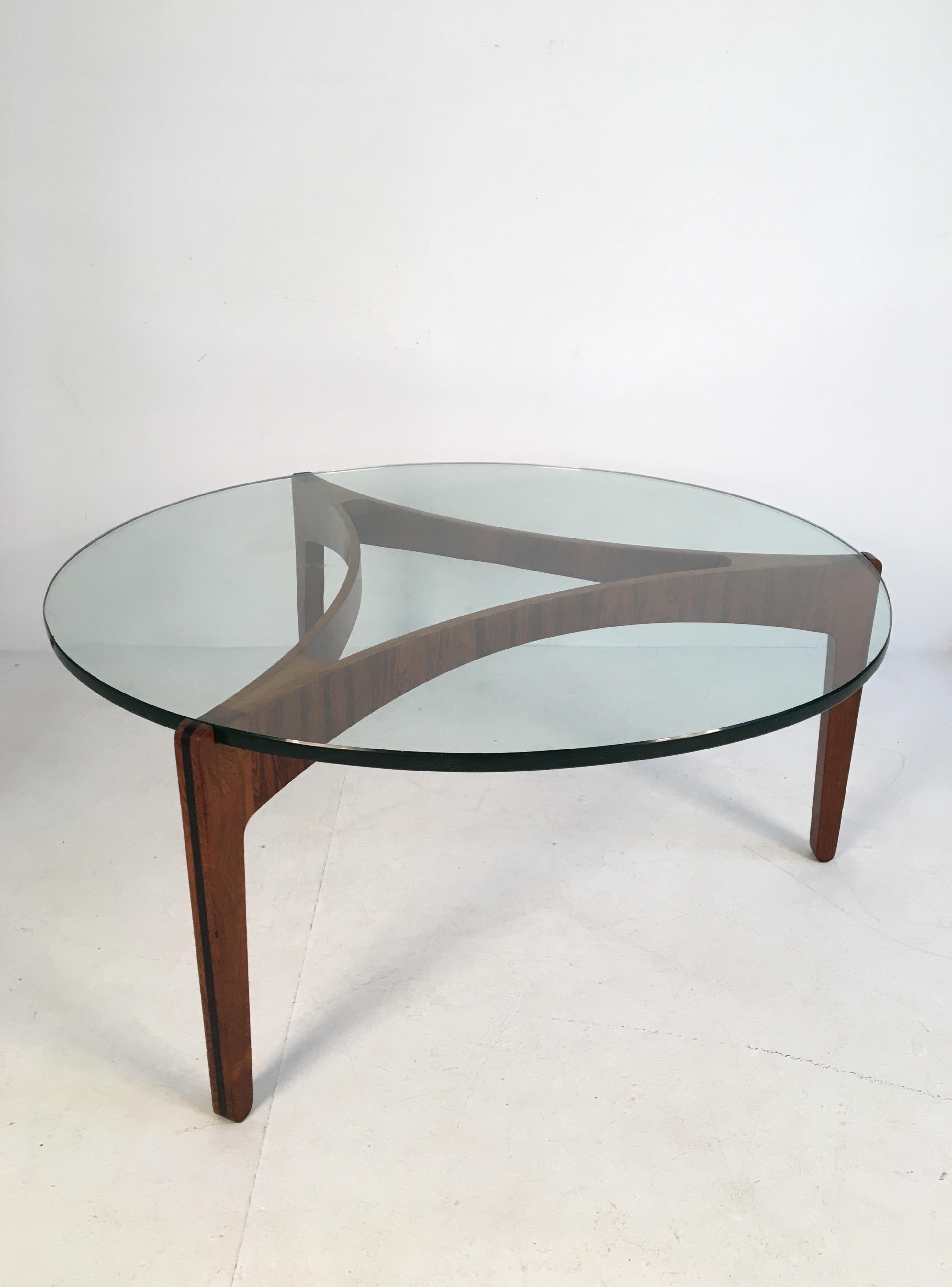 Exquisite coffee table designed by Sven Ellekaer for Christian Linneberg Mobelfabrik, Denmark in 1962. This elegant piece is composed of a beautiful bent rosewood base supporting a thick tempered glass table top.