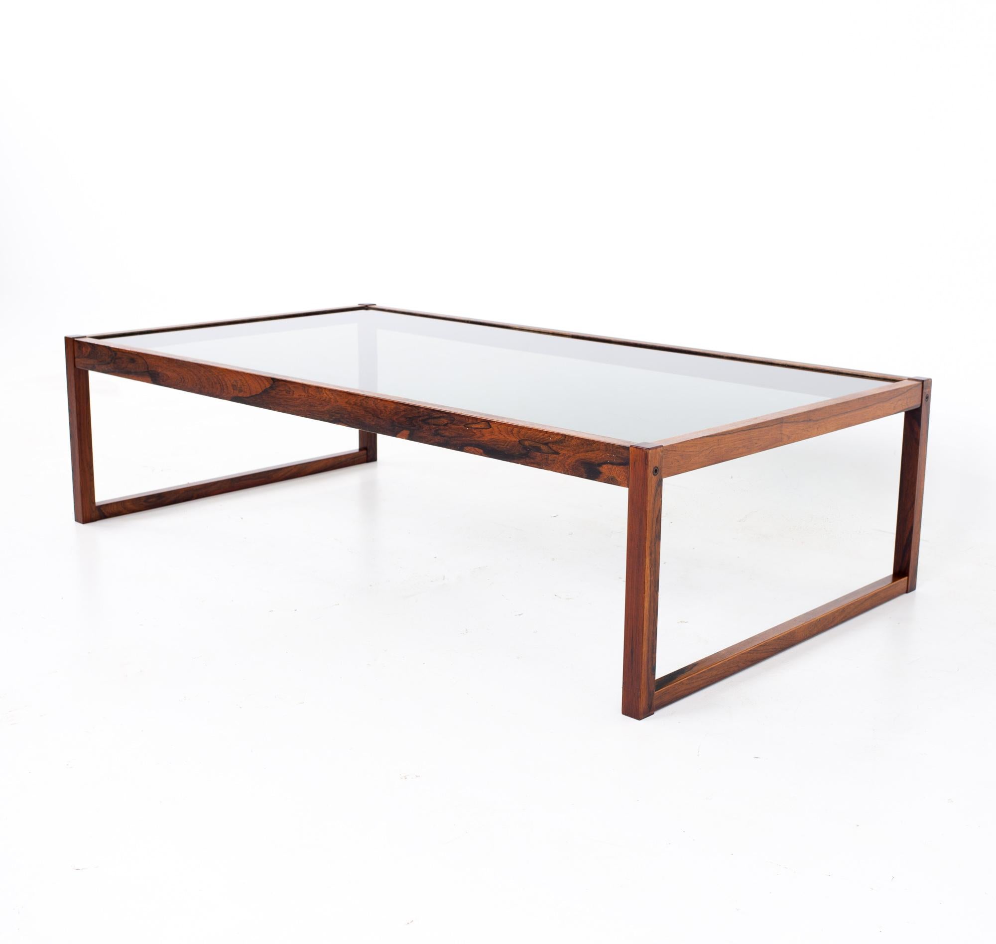 Midcentury rosewood and glass coffee table
Table measures: 57 wide x 31 deep x 15 inches high

All pieces of furniture can be had in what we call restored vintage condition. That means the piece is restored upon purchase so it’s free of