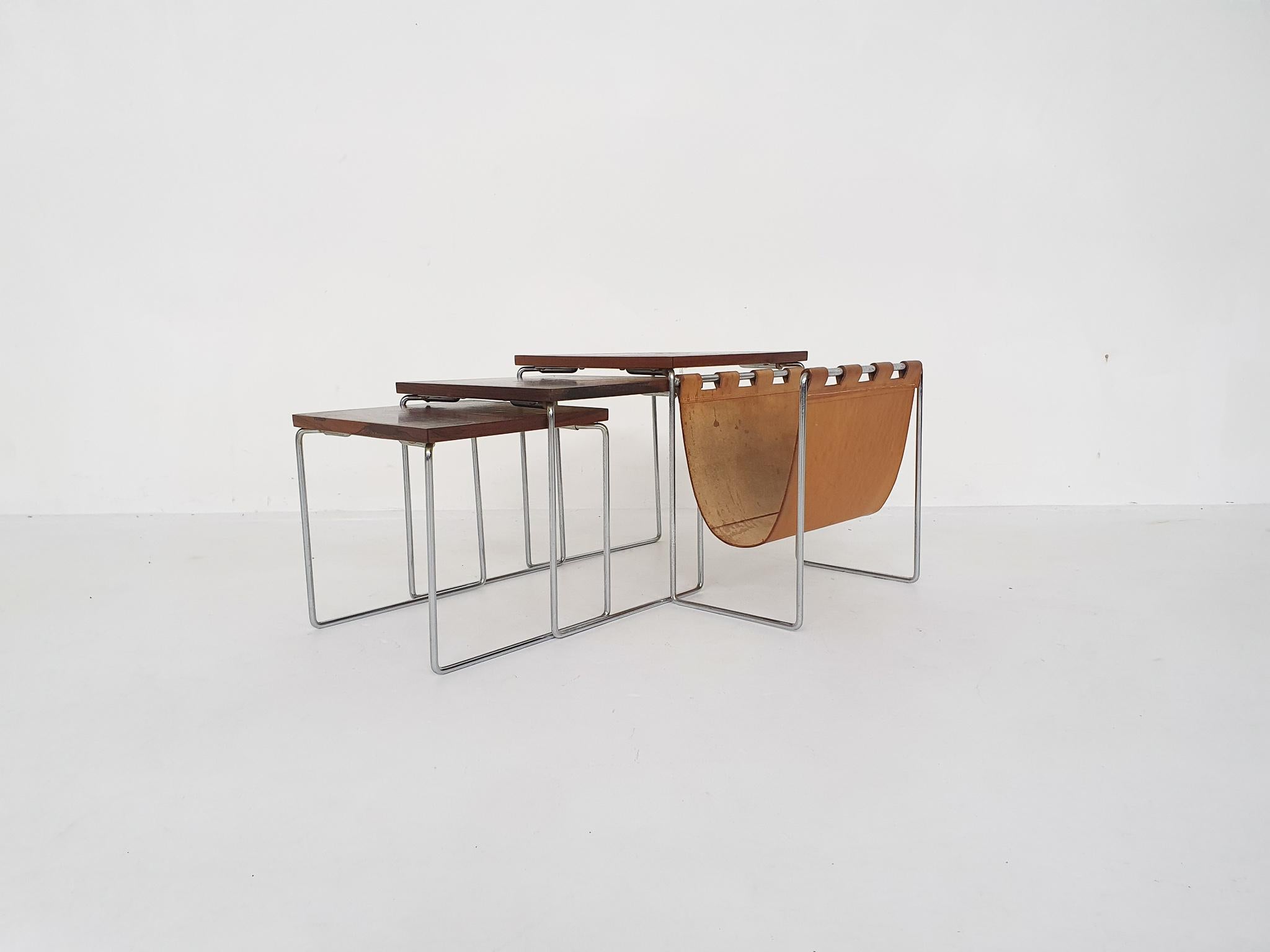 Set of three rosewood veneer and metal nesting tables. The large one has a cognac saddle leather magazine rack.
Some traces of use.
Large: 56 x 34.5 x 37cm (LxWxH)
Middle: 32.5 x 32.5 x 34cm (LxWxH)
Small: 30 x 30 x 31 cm (LxWxH).

 