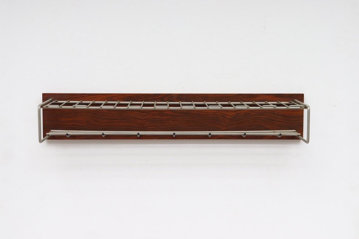 Beautiful Mid-Century Rosewood and metal wall mounted coat rack. Rosewood veneer frame with aluminum hangers and black plastic cap accents. In original condition with moderate wear and scratching consistent with age.