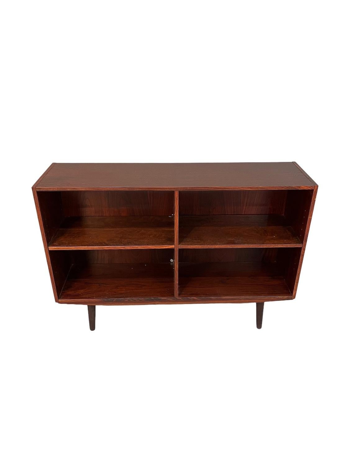 Mid-Century rosewood low bookcase from 1960's era with 4 storage shelvings and wood legs 
dimensions: W47 x D11.5 x H33 inches 
good condition for age and use