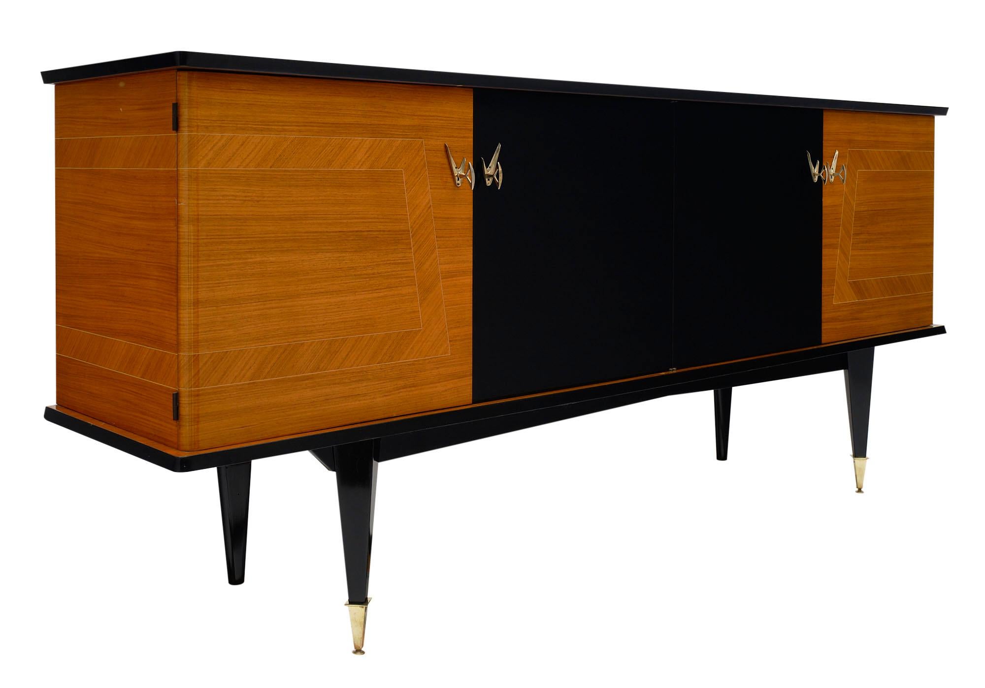 Buffet / enfilade from France made of inlayed rosewood and ebonized rosewood. The piece is supported by tapered legs; the front two feet are capped in brass. There are four doors which open to shelving and drawers. This credenza can also be used as