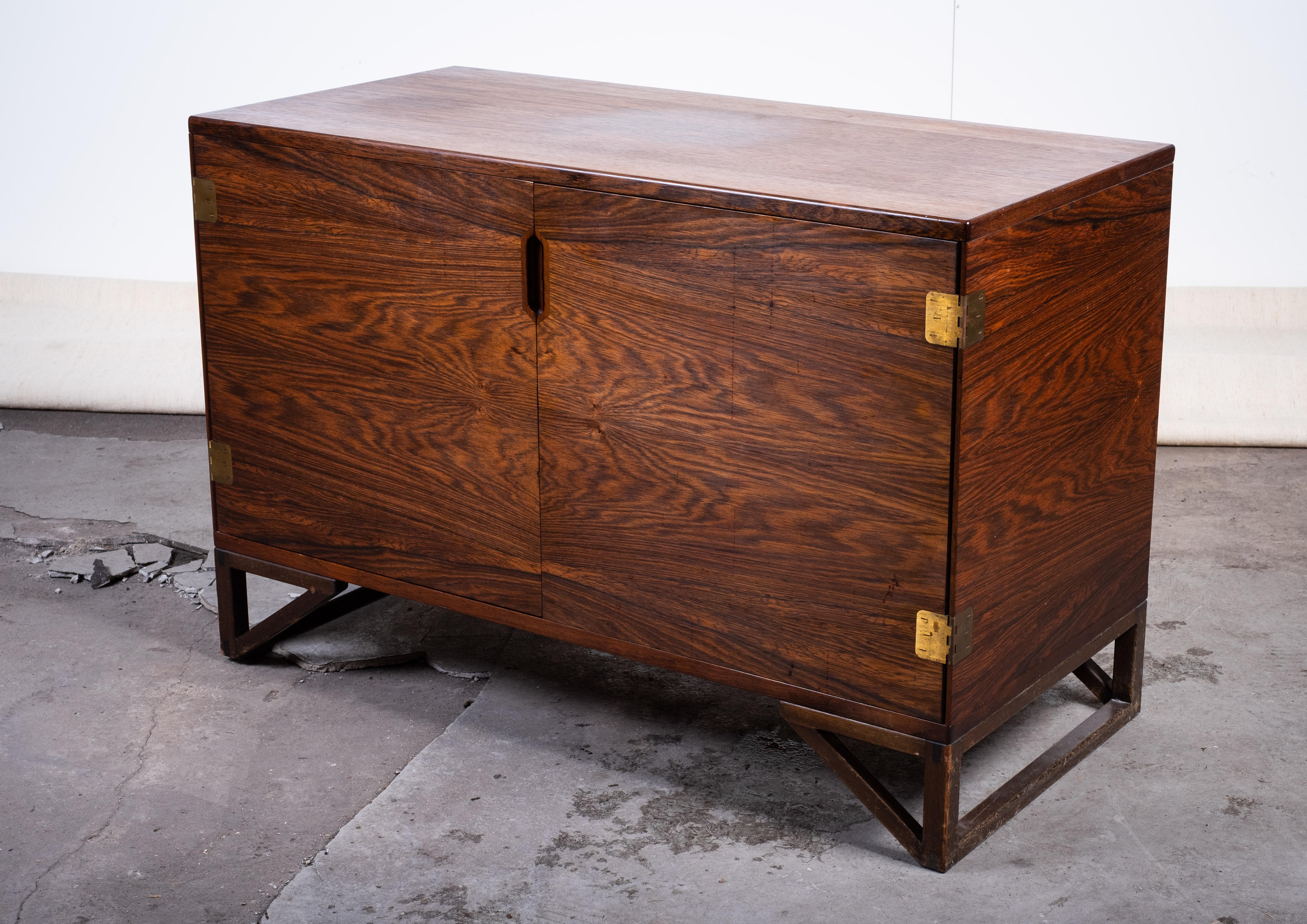 Elegante mobile danese del Mid-Century Modern progettato da Svend Langkilde e prodotto da Langkilde Møbler per Illums Bolighus. Realizzato in impiallacciatura di palissandro dalle venature ricche e con raffinate cerniere in ottone.

Le due ante si