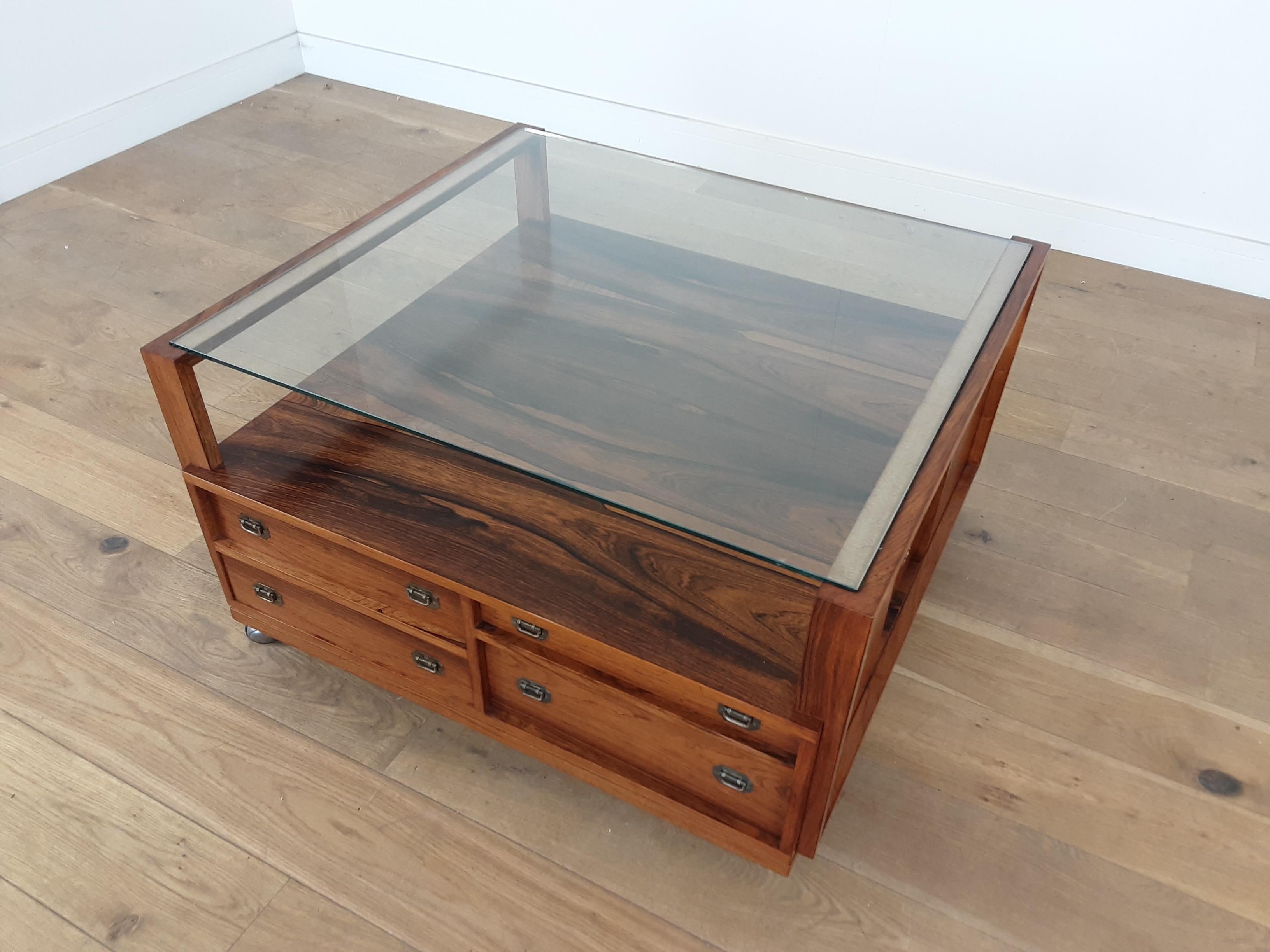 Midcentury rosewood table with lots of drawers and compartmented drawers and storage spaces.
A very versatile centre table on castors for easy movement, beautiful rosewood with practical plate glass top.
Measures: 50 cm H 85 cm W 89.5 cm D
Danish