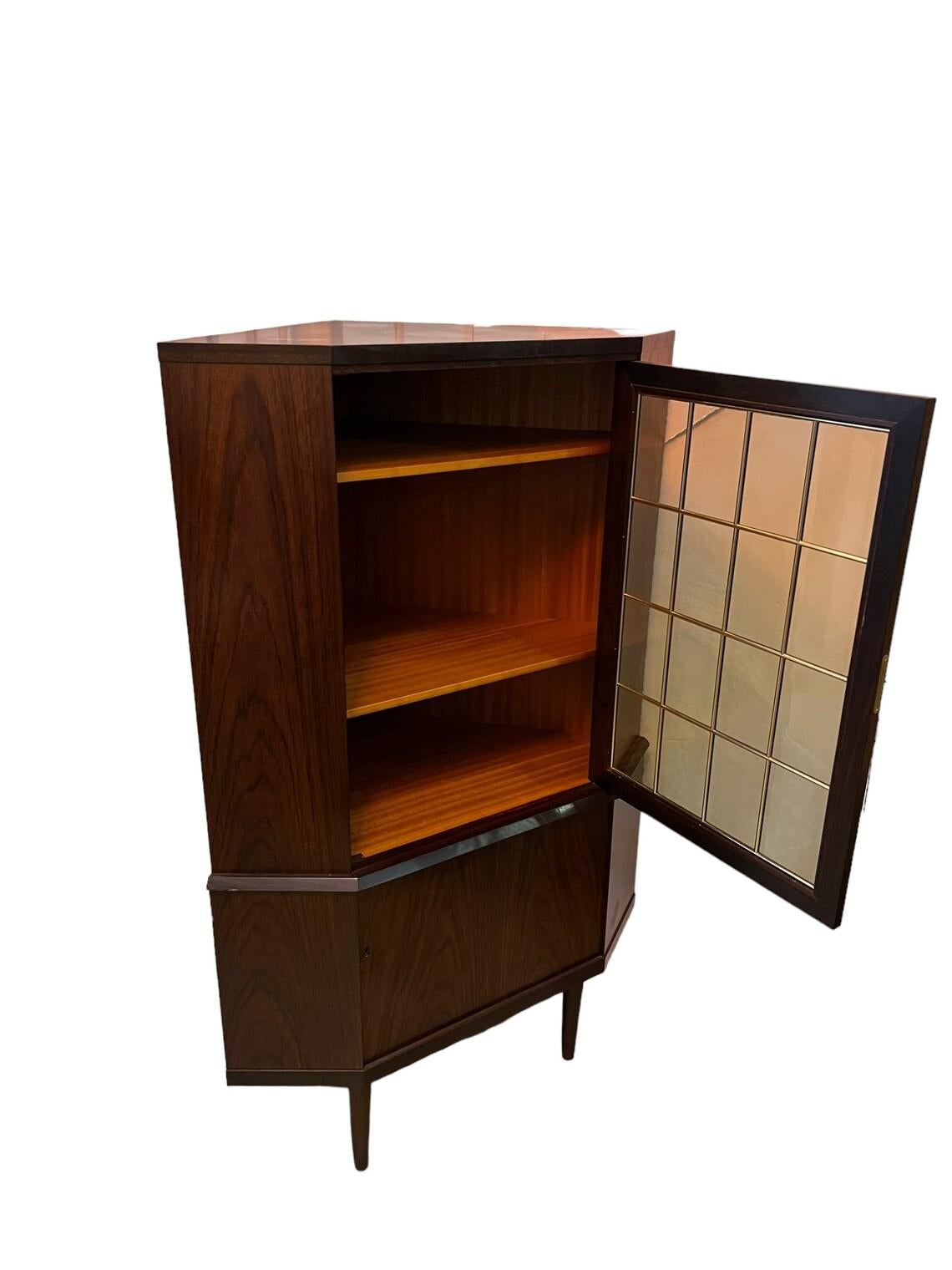 Mid Century Rosewood, Danish corner cabinet with glass doors, adjustable shelving on the top and the bottom sturdy and heavy very good condition 1960 Circa.
Dimensions: W 34