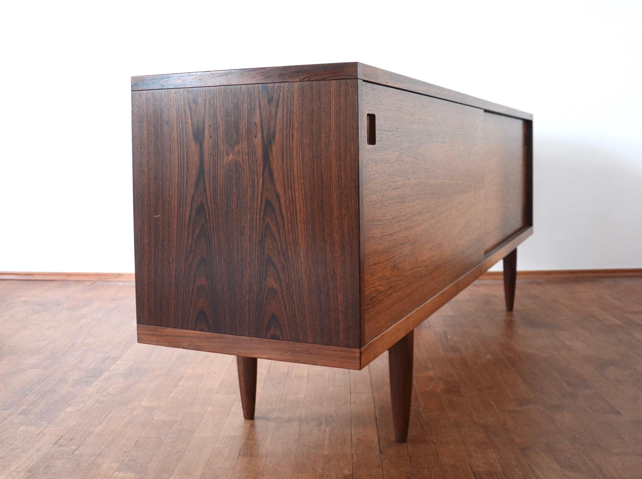 Very rare and exquisite midcentury rosewood credenza M20 by famous N.O. Møller manufactured by J.L. Mollers, Denmark - partly solid with beautiful veneers. The sideboard has two sliding doors, solid shelves and four adjustable drawers of rosewood