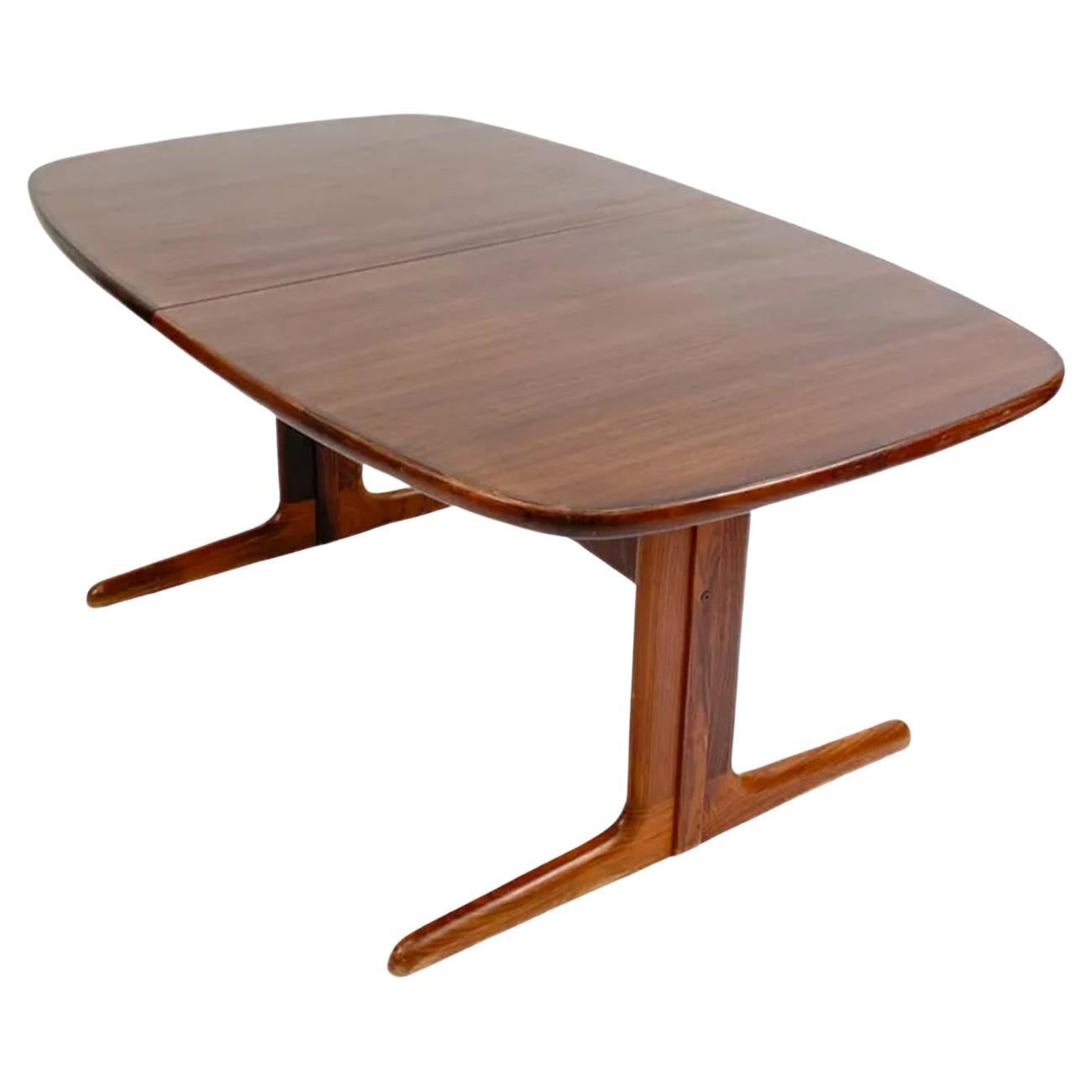 Mid century rosewood rounded Danish Modern extension dining table with (2) leaves. This table has Solid rosewood wood legs. This table is in beautiful condition with Dark black and reddish rosewood tones very great Table. This table Comes with (2)