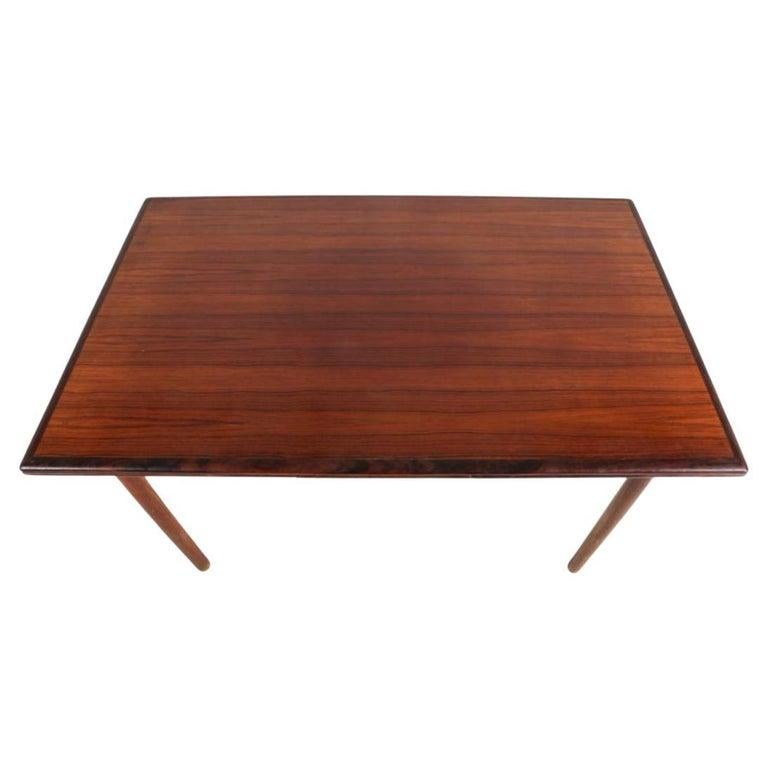 Table de salle à manger à rallonge en bois de rose rectangulaire du milieu du siècle avec (2) rallonges gigognes. Cette table a des pieds ronds et effilés en palissandre massif. Cette table est en bon état vintage avec des tons de palissandre