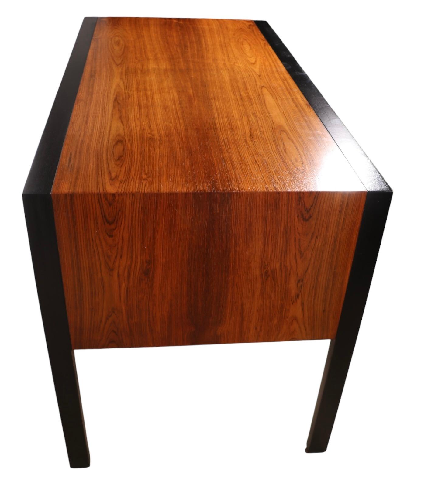 Bureau d'architecte chic, conçu par Harvey Probber, vers 1950/60. Le bureau présente un plateau, des côtés et des façades de tiroirs en bois de rose vibrant, avec des garnitures et des pieds noirs graphiques contrastés et des garnitures décoratives