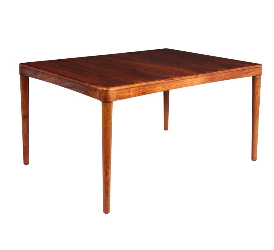 Midcentury rosewood dining table by H W Klien for Bramin.
Produced by Bramin in the 1960s, with sculpted rosewood edging and turned legs this table has been re finished and in very good condition, having one wide leaf with apron, the leaf stores