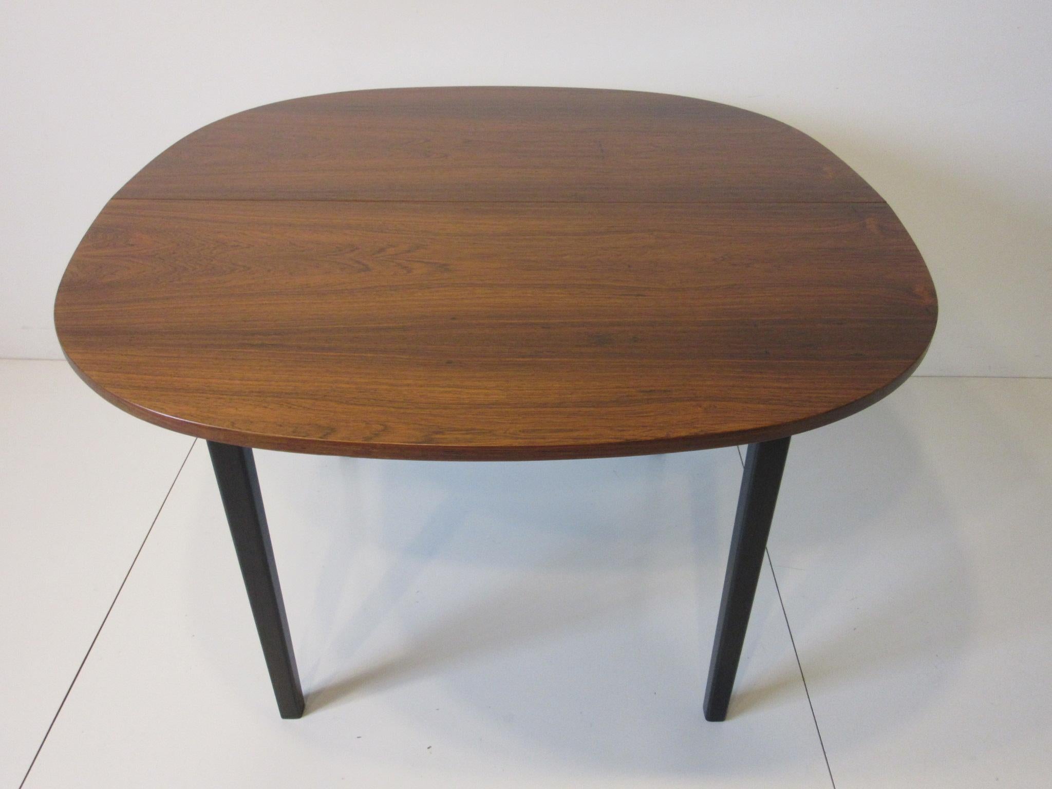 A well grained book matched Brazilian rosewood dining table with two 15