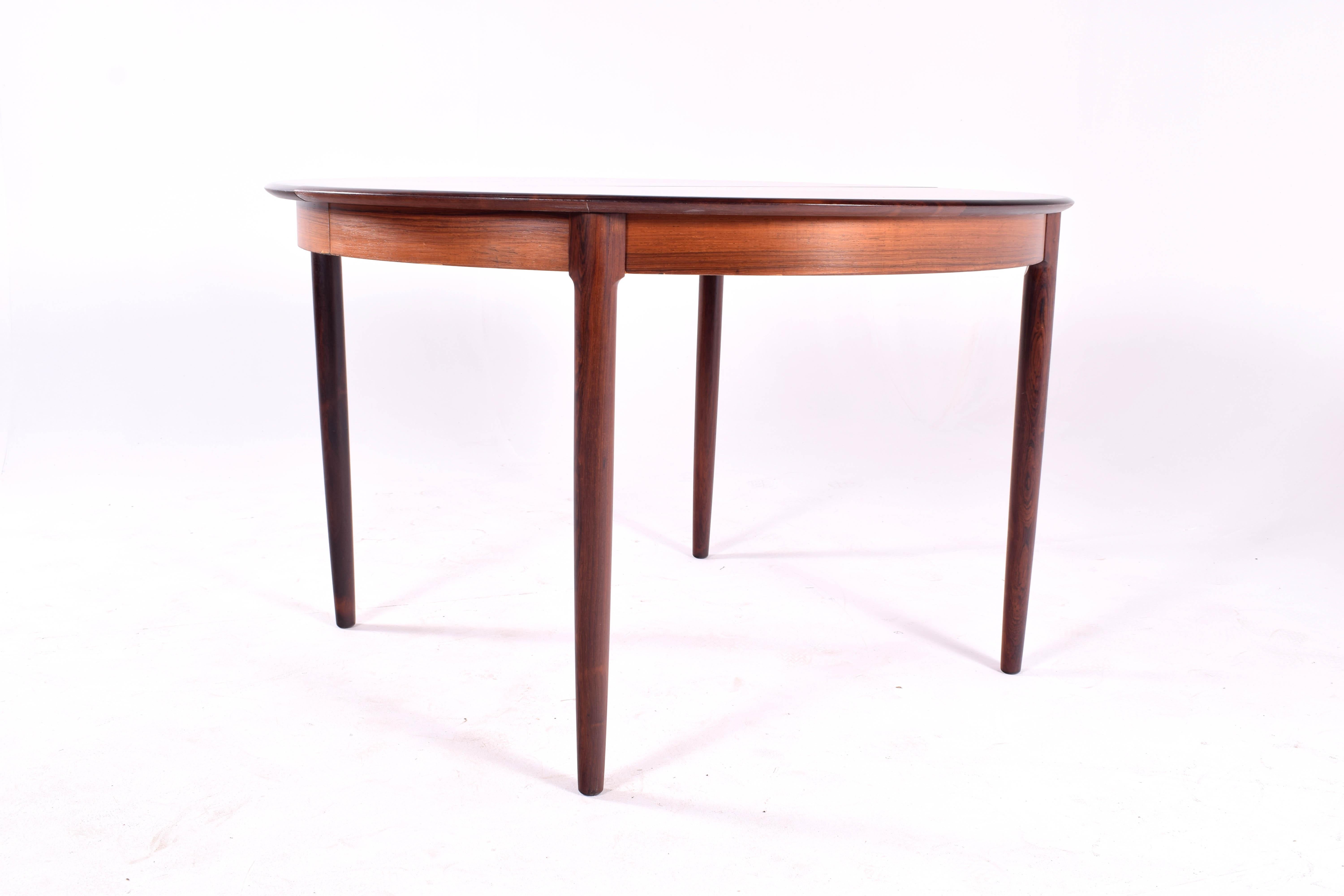 A rosewood table by Niels Moller for J.L. Moller. The design of this piece is ingenious. The quality of this piece is magnificent. Solid rosewood banding and legs are used in the construction. The convex leg detail adds beauty to the table. This