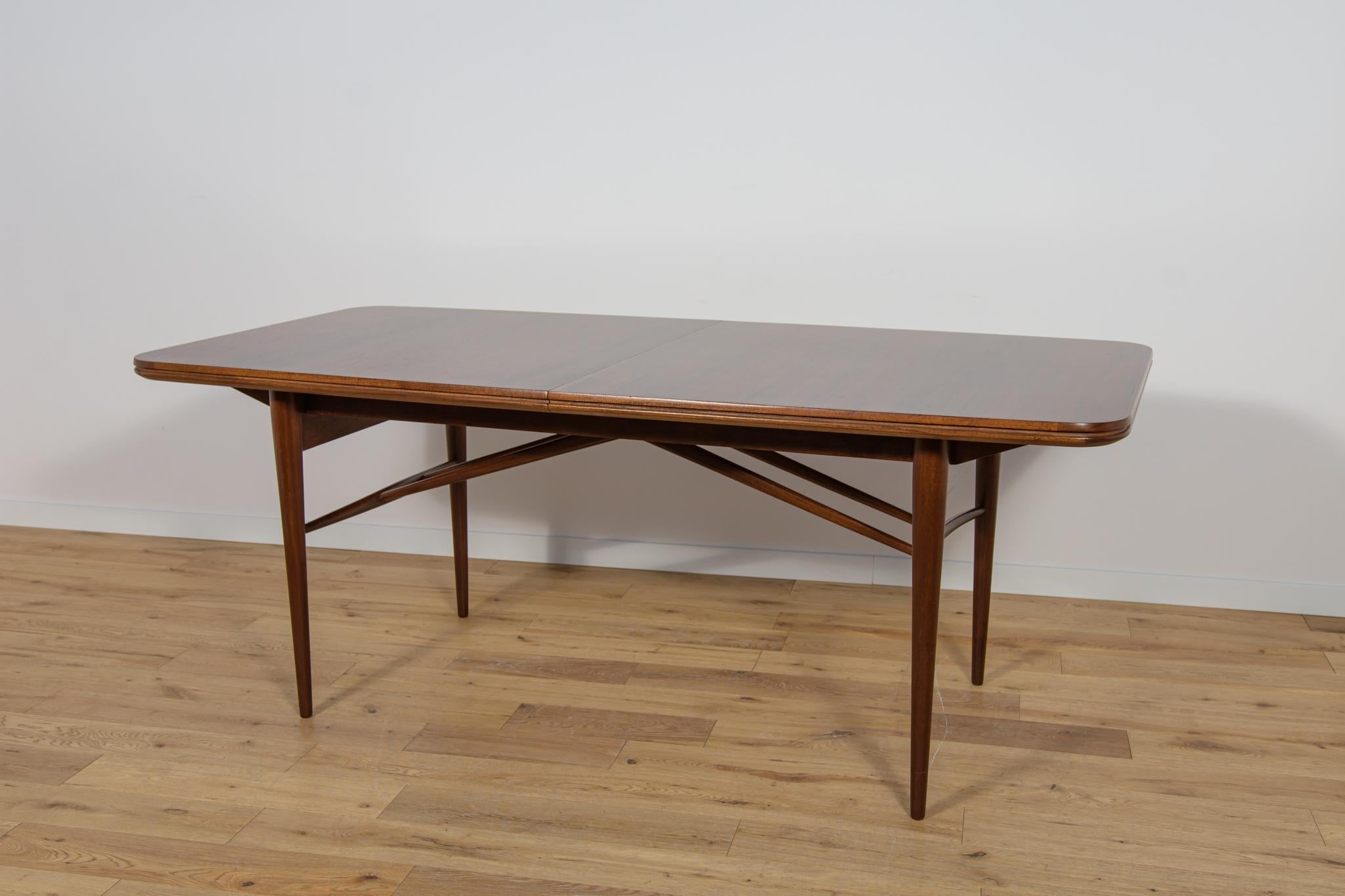 The dining table by designe Robert Hertige for the British manufacture Archie Shine in the 1950s. The dining table was made of rosewood.The table is a great example of British Mid Century style, characterized by high quality of design and