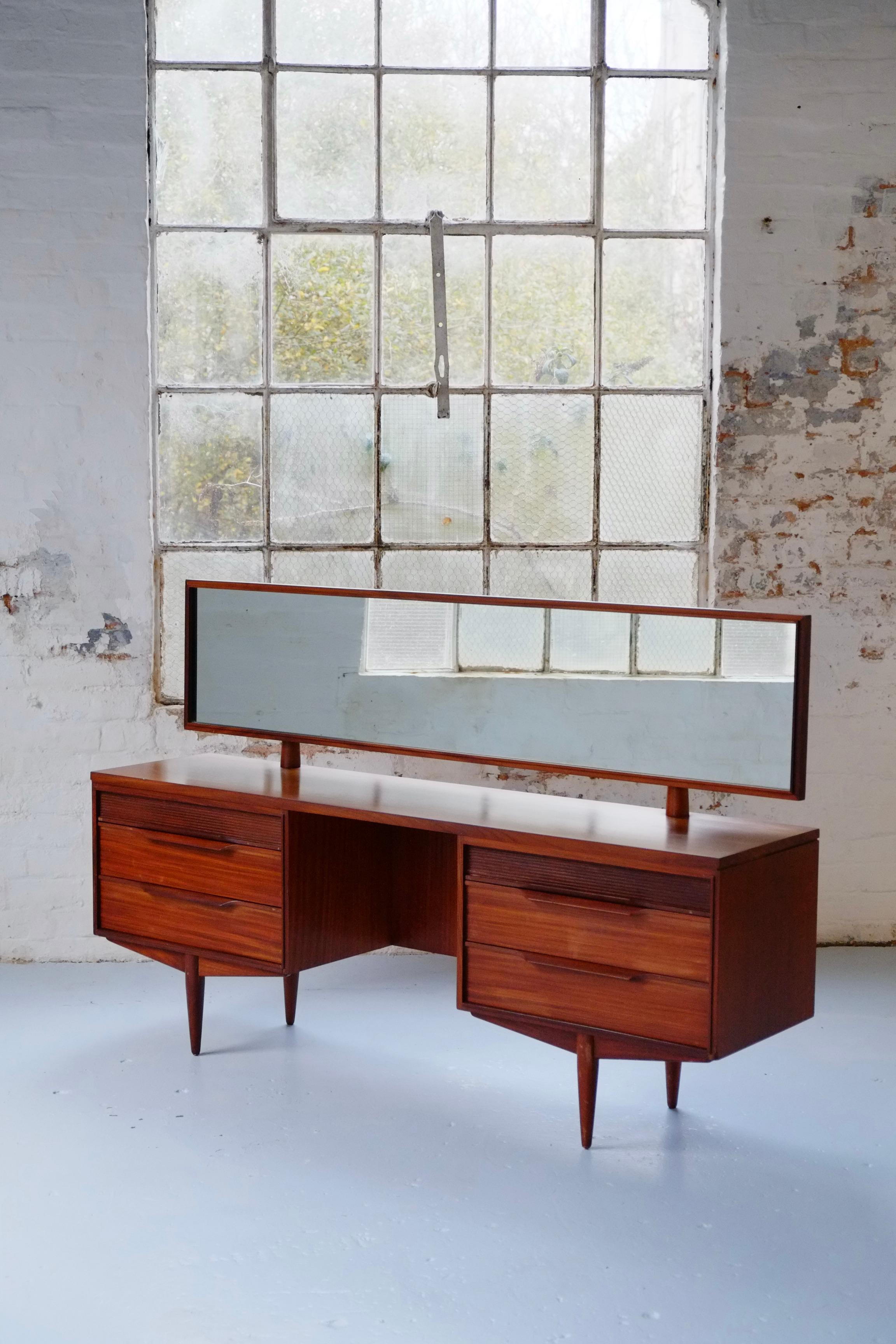 A long elegant mid century dressing table and stool by Arthur Edwards for White and Newton. England C1960. Featured in the 1961 book Contemporary Design in Woodwork. 

This elegant dressing table is beautifully made in two tones of wood - I think