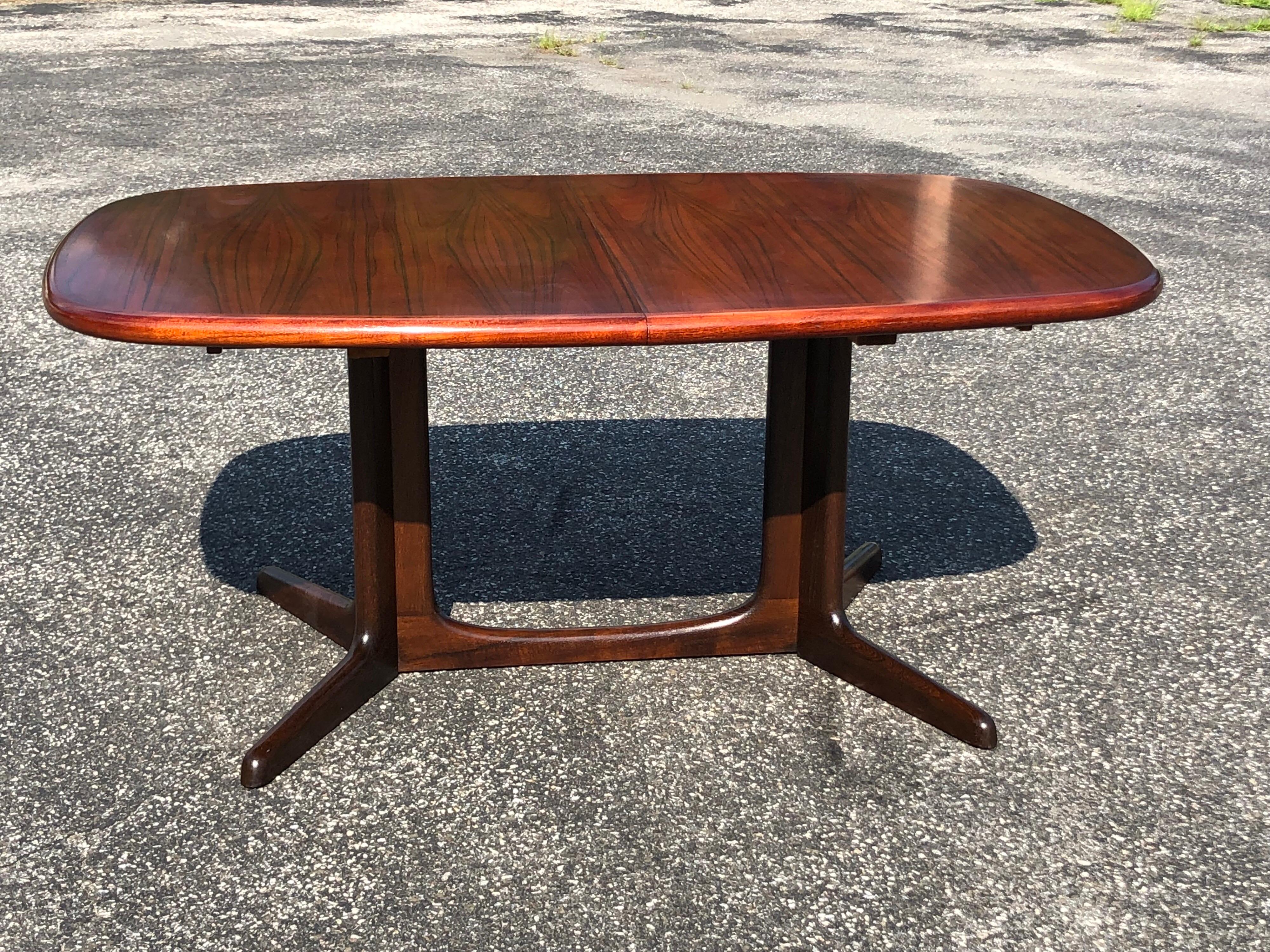 Mid-Century rosewood extension table by  Niels Otto Moller for Gudme Mobelfabrik. Comes with two leaves. Amazing tones to this smartly designed table. The simple double pedestal base is Classic in style as well as the rounded oval lines. Seats up to
