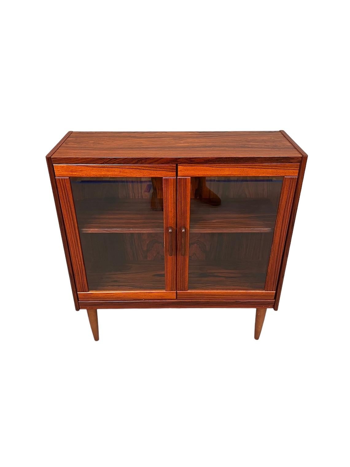 Mid-Century Rosewood glass cabinet 

Dimensions:
L:33 D:12 H:35 inches

Condition:
very good for age and use 