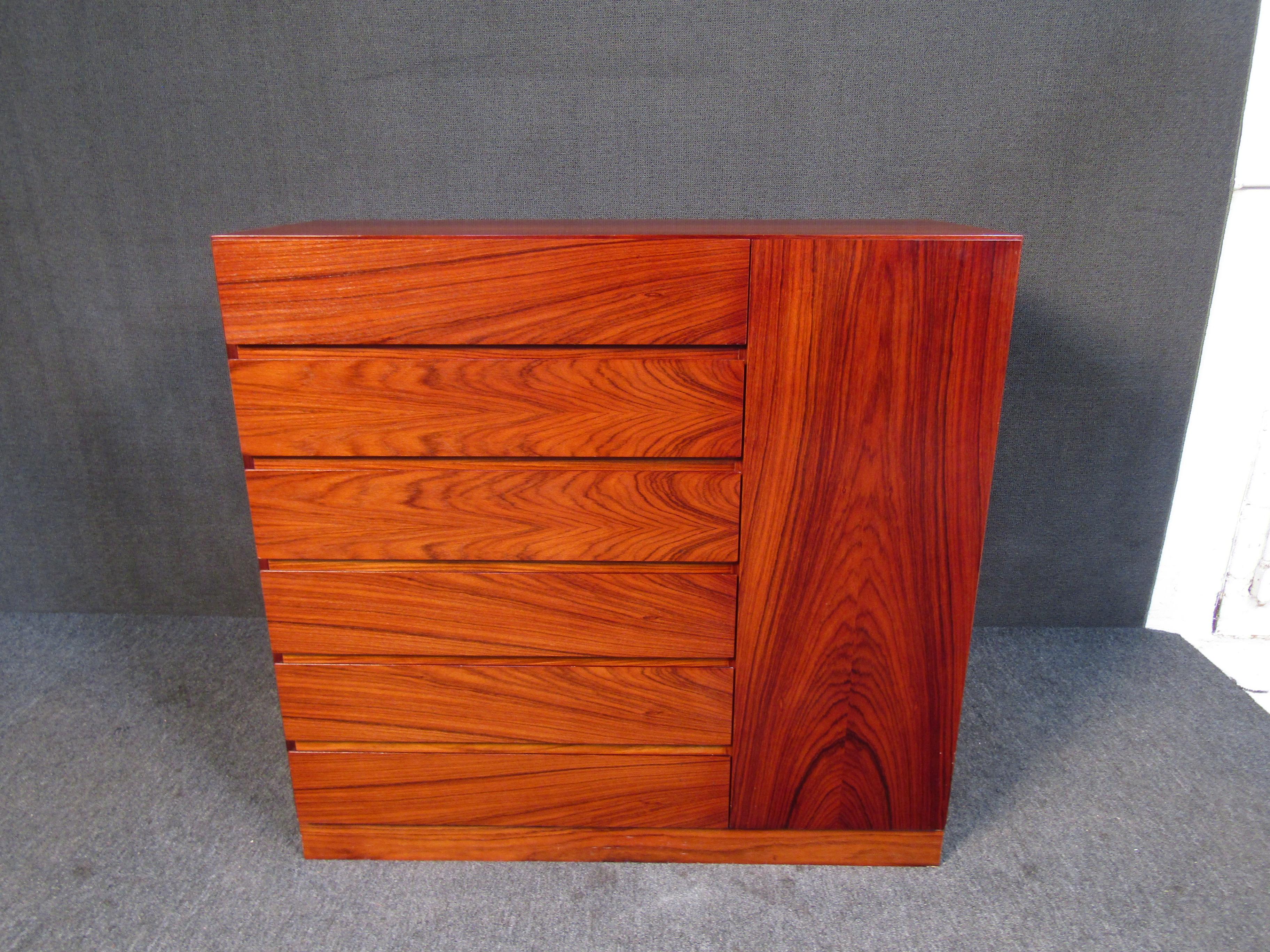 This vintage highboy dresser offers plenty of storage in a minimal Mid-Century Modern design. Beautiful warm rosewood woodgrain surrounds the piece, making this a beautiful addition to any bedroom. Please confirm item location with seller (NY/NJ).