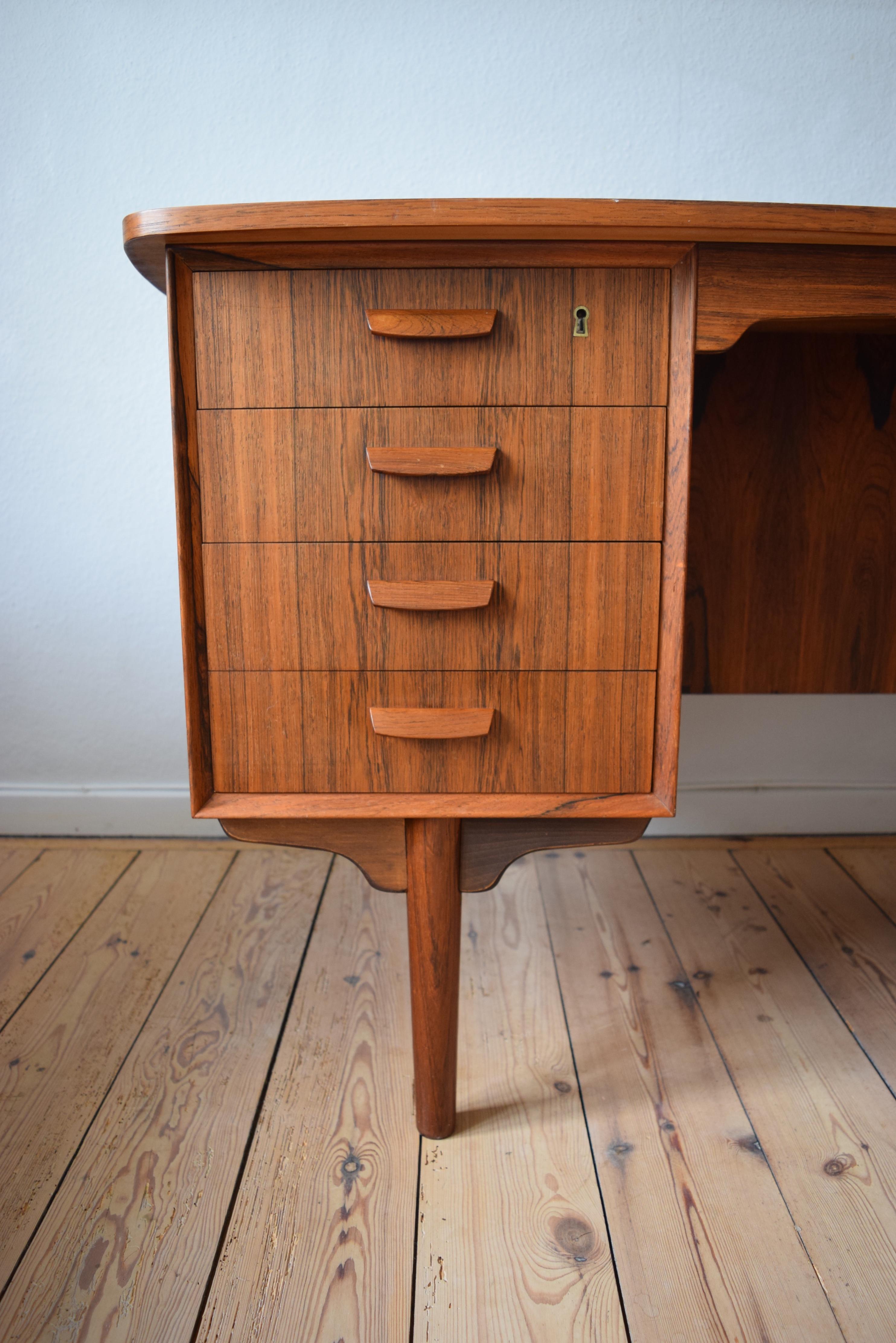 This rare Danish modern atomic midcentury rosewood writing desk was manufactured by H.P. Hansen Møbelfabrik in the 1960s. Looking good from every angle, this gorgeous piece features bowed front and rear locking doors, which open to a parabolic