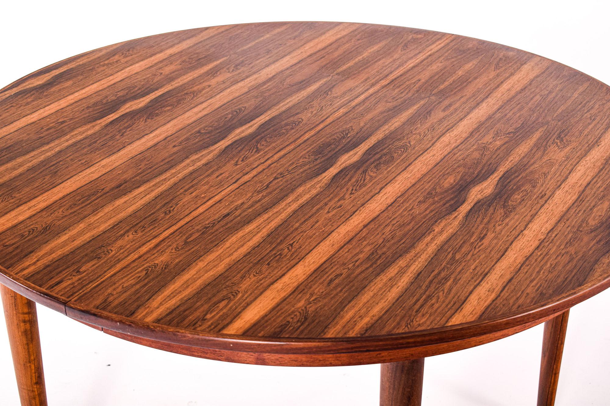 Round extendable dining table in rosewood. Simple and beautiful tapered cigar legs, with two additional extension leaves, 50cm, for the guests.
Amazing veneer on top, around and on the legs, exhibiting all the vivid nuances of rosewood.