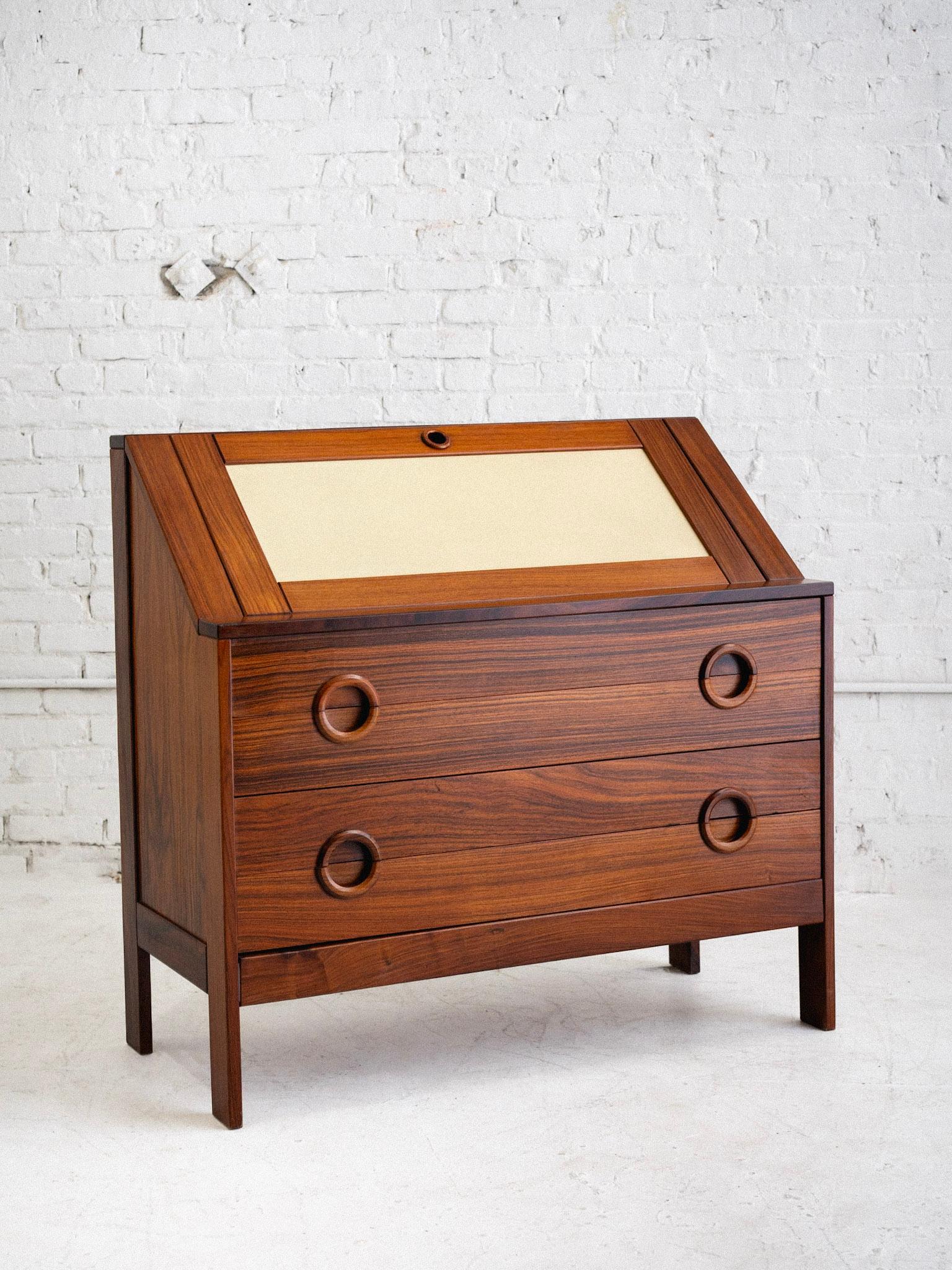 A mid century Brazilian rosewood drop front secretary desk. Rich wood grain with beige laminate accent panels. Sculpted handles on four lower drawers. Sourced in Northern Italy.