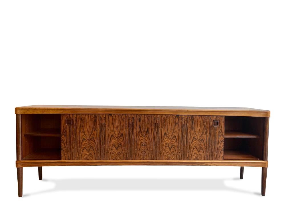 This high quality Danish rosewood sideboard was designed by H. W. Klein for Bramin, 1960s.

Features two sliding doors either side concealing shelves and 5 central drawers set on thin legs. 

Really beautiful color and wood grain pattern.
 
