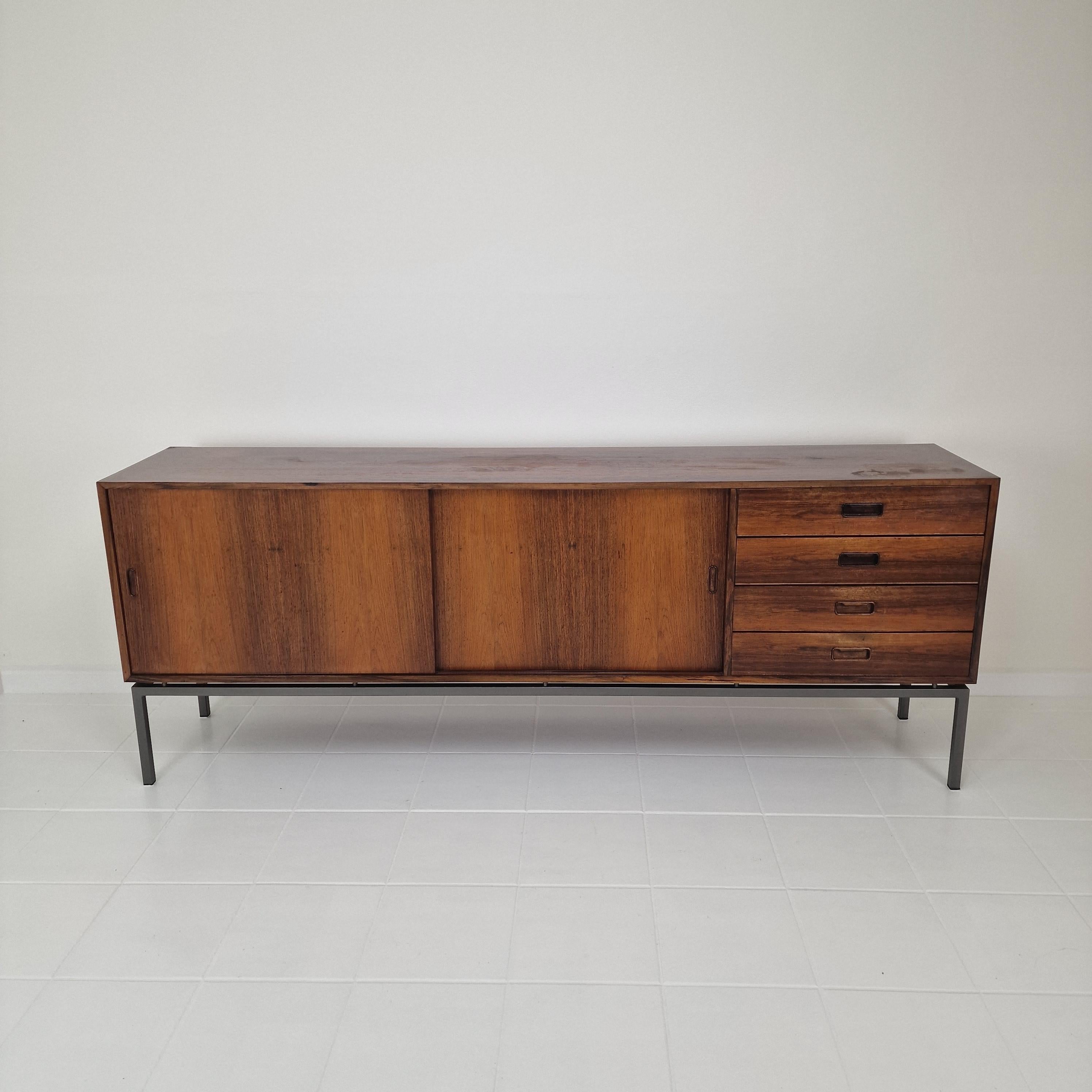 Magnifique buffet Mid Century fabriqué par Topform aux Pays-Bas, années 1960.

Ce très beau buffet aux formes élancées est réalisé en bois de rose plaqué et grainé, avec des pieds en métal massif. 

Il comporte deux portes avec des étagères à gauche