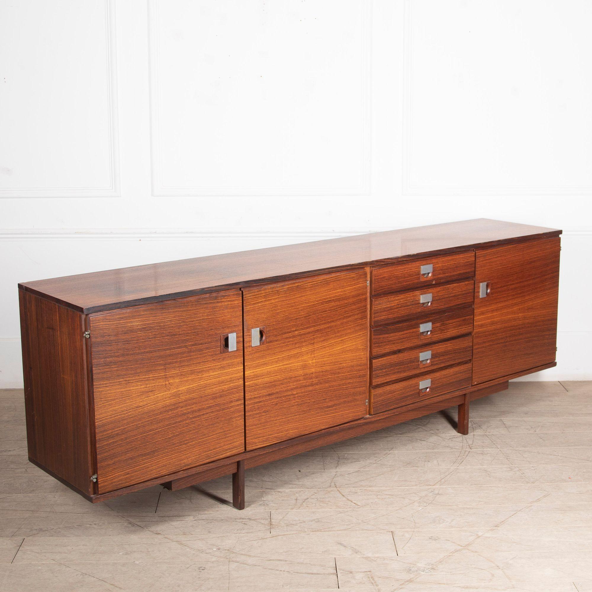 Fabulous Mid-Century rosewood sideboard.
With five small drawers and six separate shelf spaces, this makes a very functional piece of storage.
There are a few scratches and a little veneer missing but overall it is in good condition for its age.