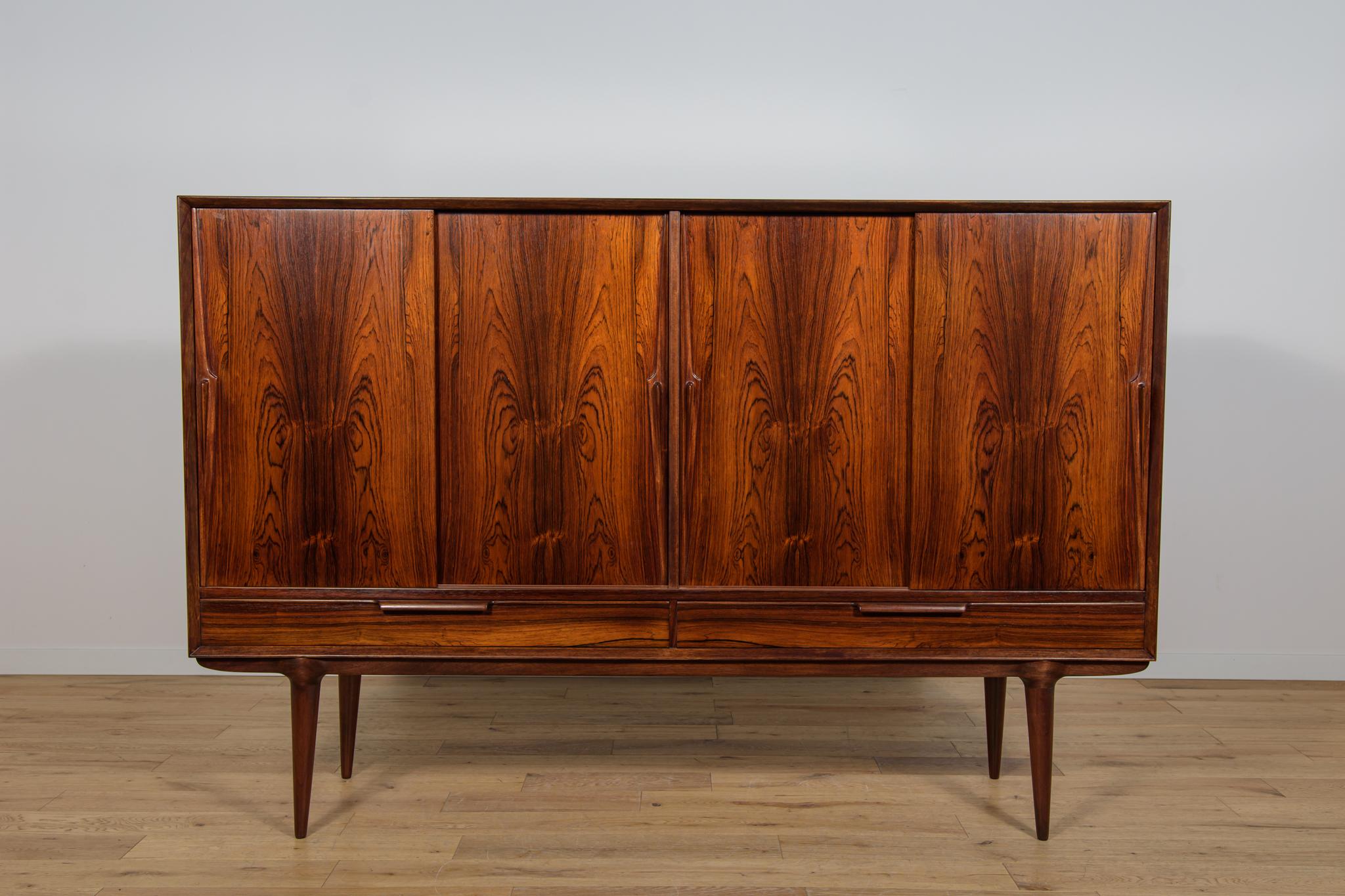 Tavola alta Modello 13 progettata da Gunni Omann e prodotta dalla fabbrica Omann Jun negli anni '60. Un eccellente esempio della scuola danese di falegnameria. La credenza presenta gli squisiti dettagli e l'eccellente artigianato per cui Omann Jun e